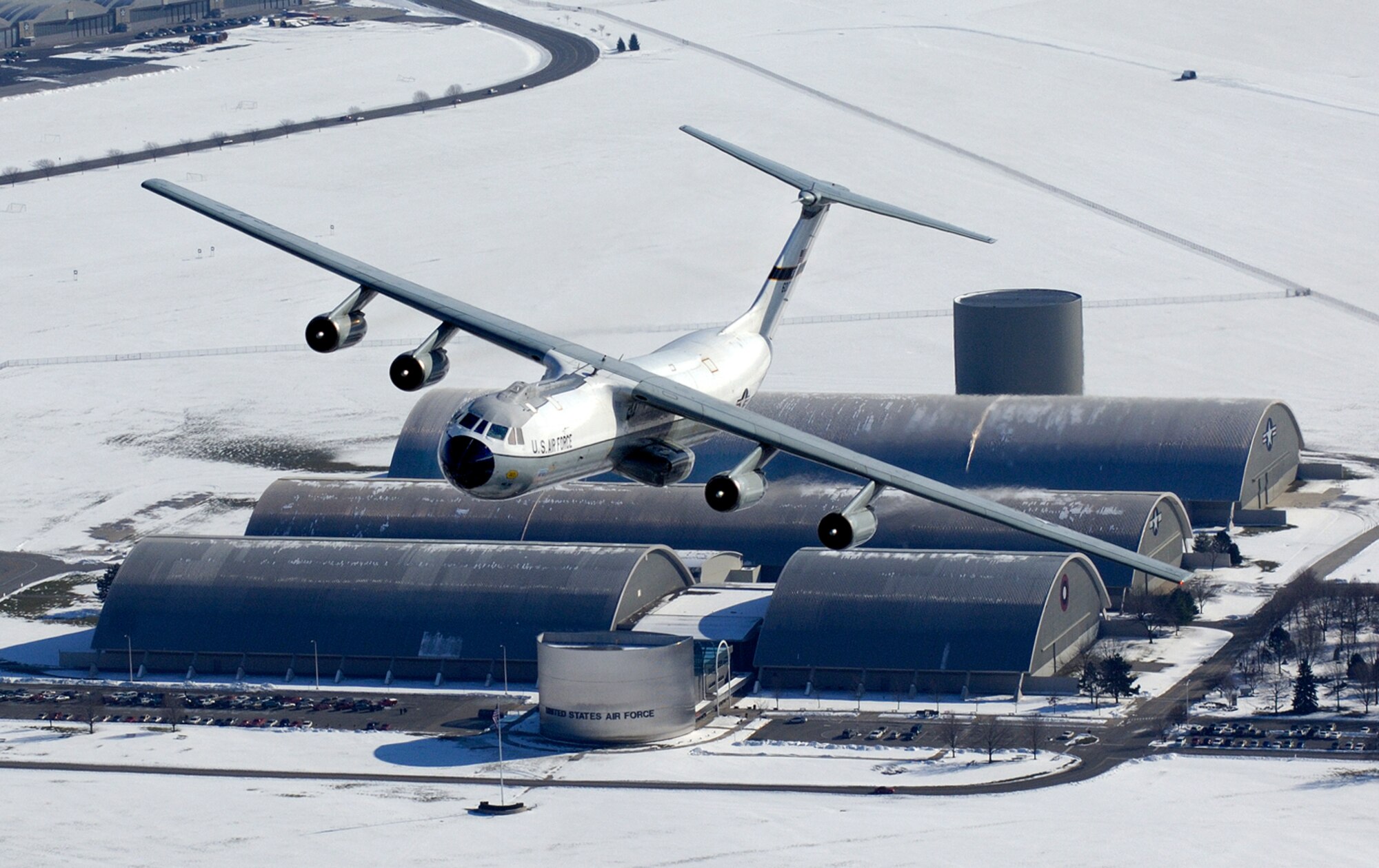 A C-141 Starlifter aircraft, better known as the Hanoi Taxi, flies over its soon-to-be new home at the National Museum of the U.S. Air Force adjacent to Wright-Patterson AFB, Ohio, Dec. 13.  This particular aircraft gained fame when it was used to return American prisoners of war back home at the end of the Viet Nam War.  As the last operational C-141 in Air Force Reserve Command's 445 Airlift Wing, the historic aircraft is scheduled to retire and be dedicated at the museum May 5-6.  The Reserve wing started replacing its C-141s with C-5 cargo aircraft in October and plan to have a total of 11 C-5s by April 2007.  (Courtesy Photo by John Rossino)

