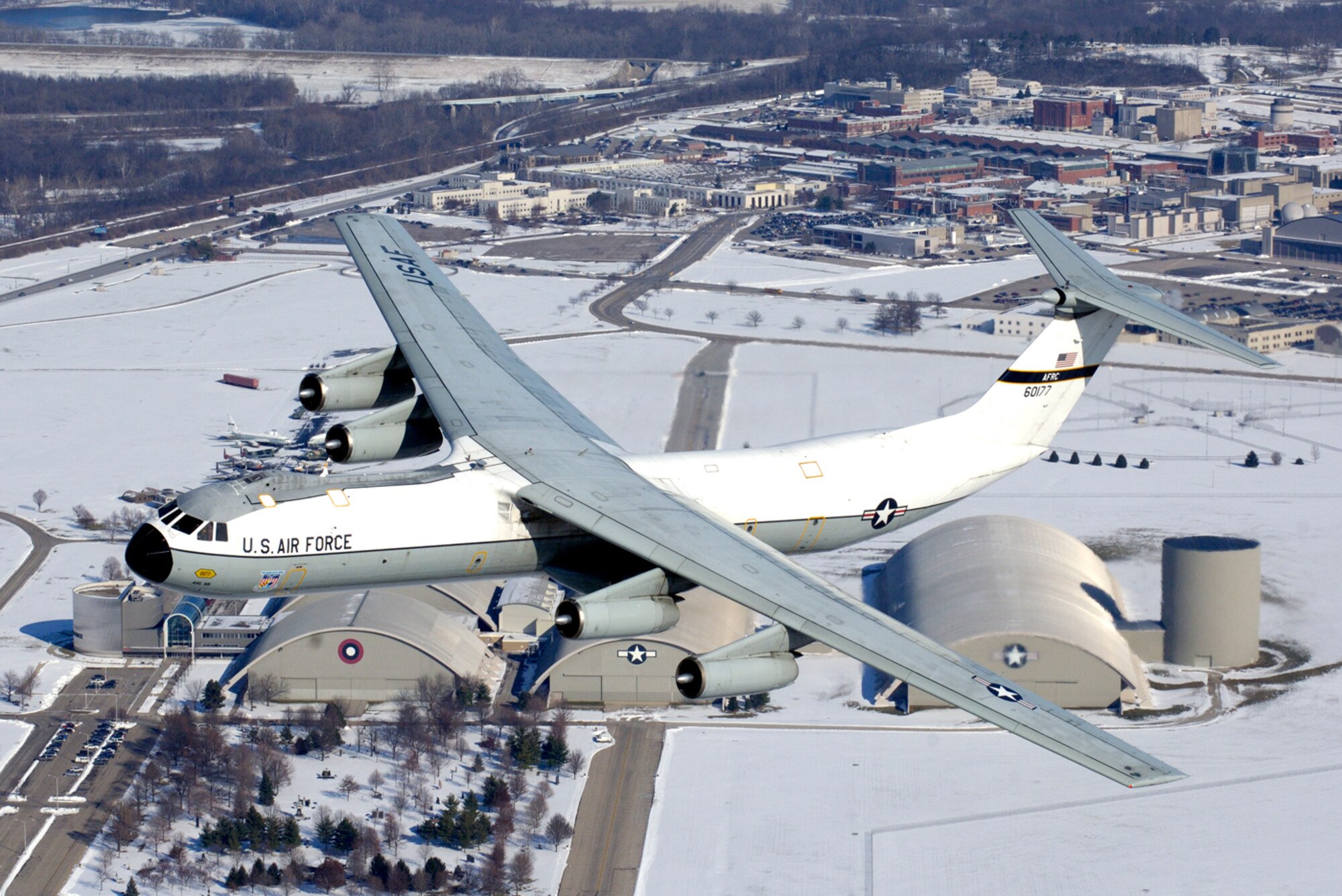A C-141 Starlifter aircraft, better known as the Hanoi Taxi, flies over its soon-to-be new home at the National Museum of the U.S. Air Force adjacent to Wright-Patterson AFB, Ohio, Dec. 13.  This particular aircraft gained fame when it was used to return American prisoners of war back home at the end of the Viet Nam War.  As the last operational C-141 in Air Force Reserve Command's 445 Airlift Wing, the historic aircraft is scheduled to retire and be dedicated at the museum May 5-6.  The Reserve wing started replacing its C-141s with C-5 cargo aircraft in October and plan to have a total of 11 C-5s by April 2007.  (Courtesy Photo by John Rossino)

