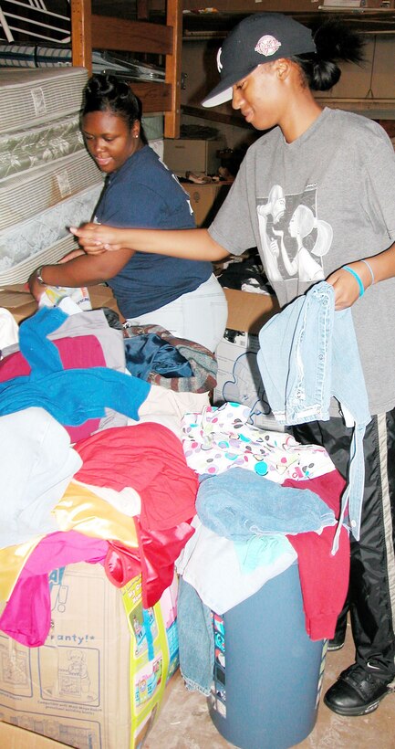 Neika Jones and Kiarrah Dixon, staff sergeants with the 970th Airborne Air Control Squadron, 513th Air Control Group, Air Force Reserve, sort through clothes and bedding donated to Katrina victims at the Sunrise Park Apartments. Sergeant Jones is secretary for the combined 507th Air Refueling Wing and 513th ACG Enlisted Advisory Council. 