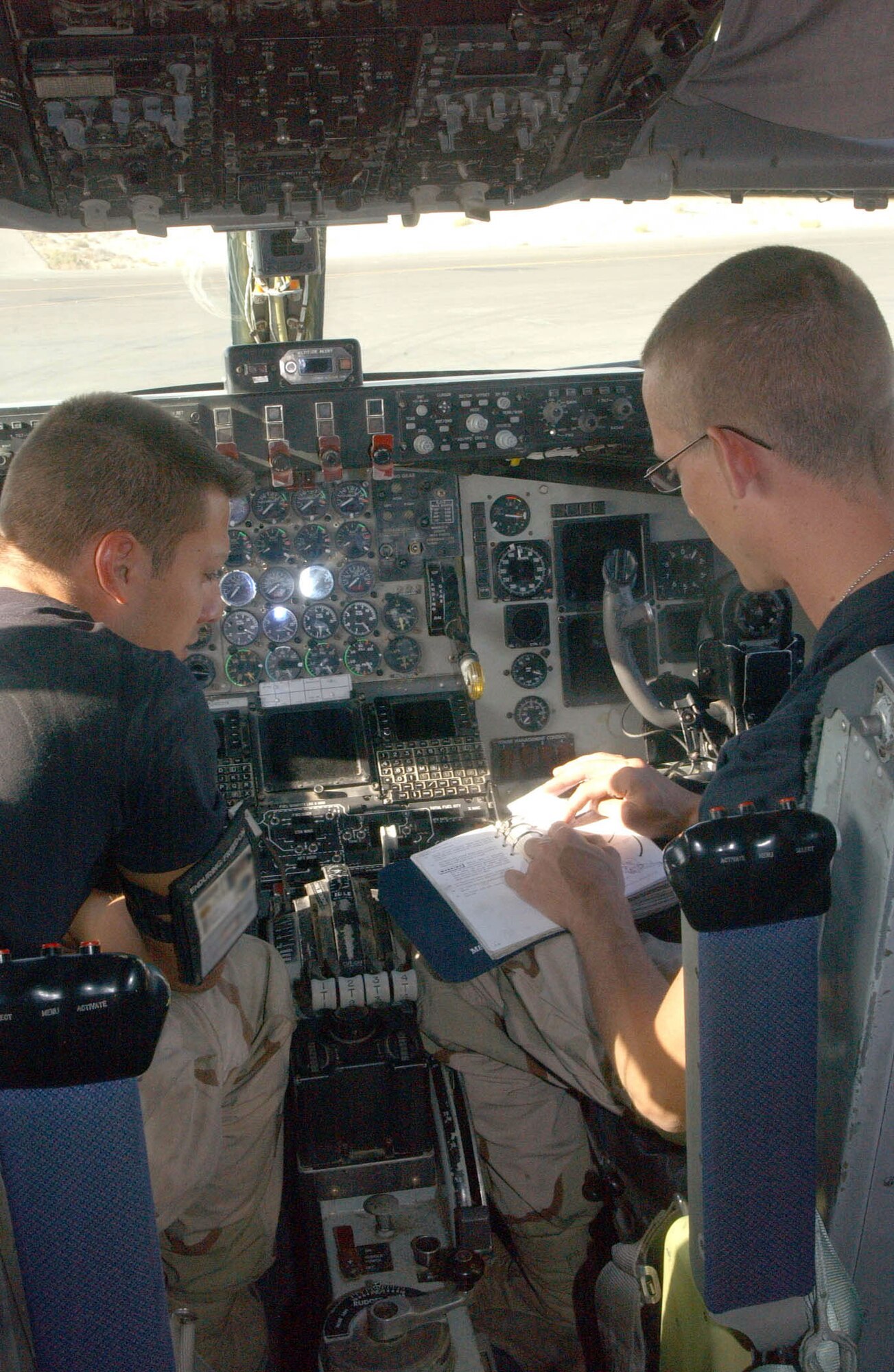 SOUTHWEST ASIA (AFPN) -- Senior Airman Ryan Winn (left) and Staff Sgt. J.C. Chandler review technical data before a maintenance engine run on a KC-135 Stratotanker at a forward deployed location.   Both Airmen are with the 380th Expeditionary Aircraft Maintenance Squadron and deployed from McConnell Air Force Base, Kan. (U.S. Air Force photo by Tech. Sgt. Mike Hammond) 