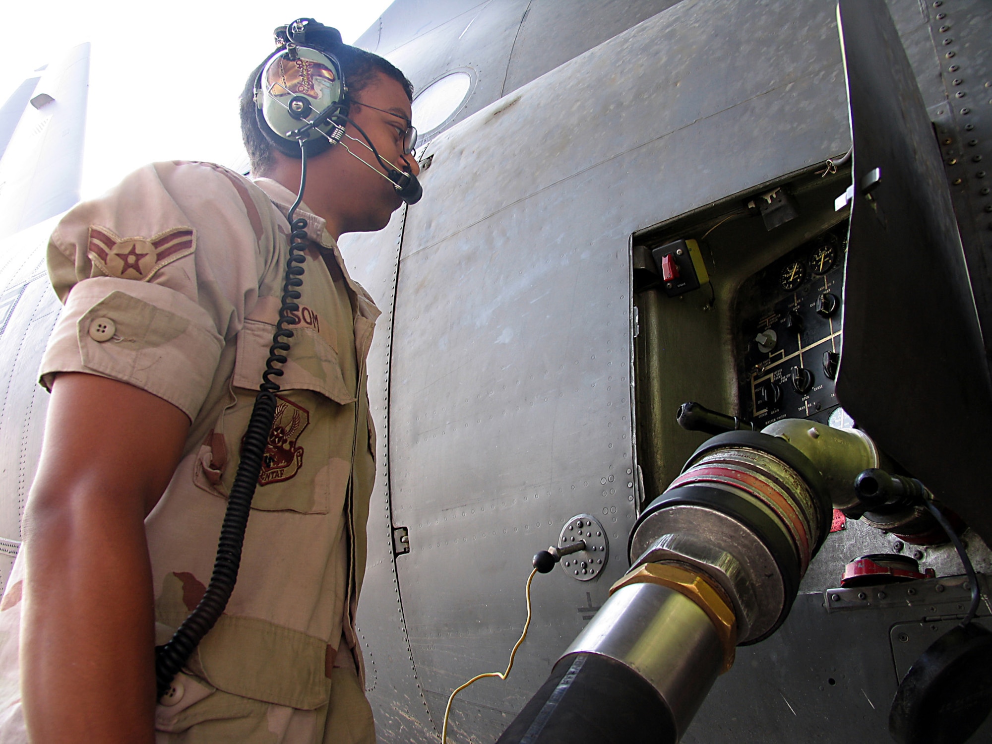 SOUTHWEST ASIA (AFPN) -- Airman 1st Class Anthony Isom hooks on the nozzle to refuel a C-130 Hercules. Airman Isom is assigned to the 386th Logistics Readiness Squadron's fuels flight at a forward-deployed location and is from Elmendorf Air Force Base, Alaska.  (U.S. Air Force photo by Tech. Sgt. Mark Getsy)

