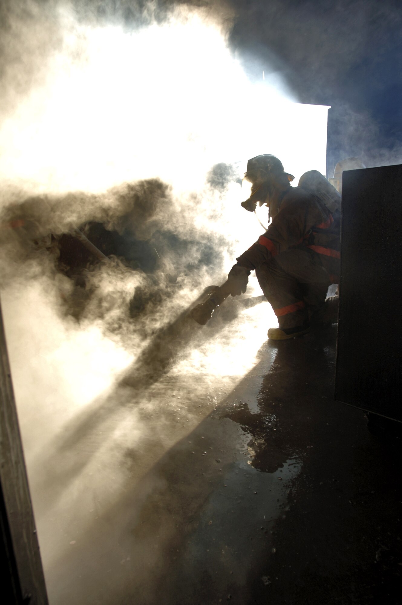 GOODFELLOW AIR FORCE BASE, Texas (AFPN) -- A firefighting student scans the smoky scene before moving to support an "attack hose" team. The students are being evaluated on their interior fire fighting skills as part of the Department of Defense Lewis F Garland Fire Training Academy's basic fire fighting course here. (U.S. Air Force photo Master Sgt. Lance Cheung)