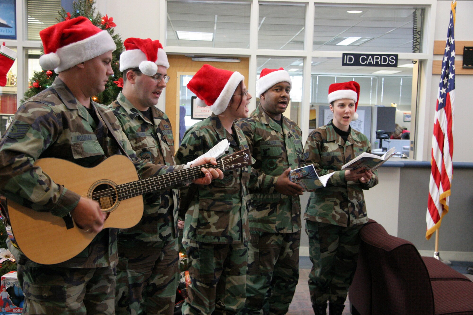 PORTLAND INTERNATIONAL AIRPORT, Ore. -- (From left) Tech. Sgt. Gary Rosenak, Senior Airman Micah Blouin, Senior Airman Bonnie Ramsey, Staff Sgt. Ronicle Ellison and Staff Sgt. Paula Goetz sing Christmas Carols to Airmen from the 939th Air Refueling Wing here. (U.S. Air Force photo by Ruby Zarzyczny)