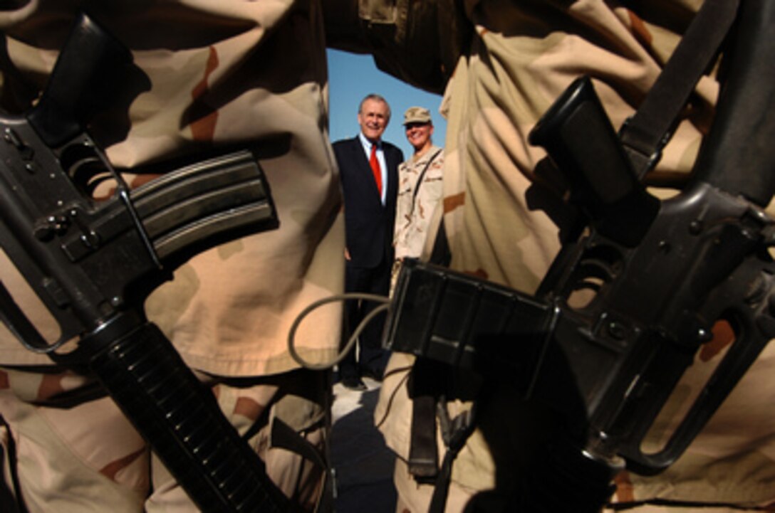 Secretary of Defense Donald H. Rumsfeld poses for a photograph with a member of Combined Task Force Bayonet at Khandahar Air Base, Afghanistan, on Dec. 22, 2005. Rumsfeld is in Afghanistan to visit and thank the troops for their service and to meet with the senior leadership. 