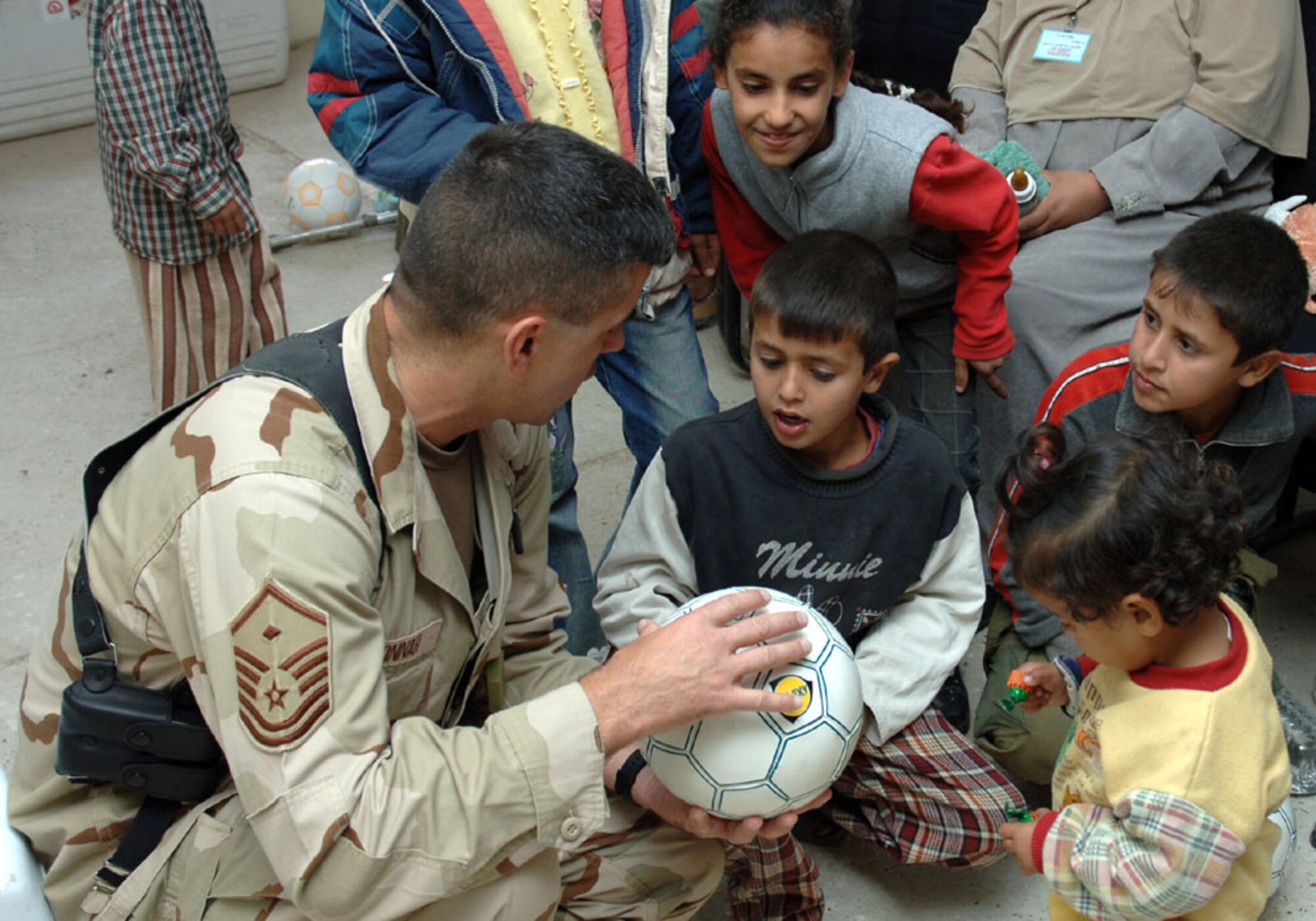 BAGHDAD, Iraq (AFPN) -- Master Sgt. Scott Bonner discusses soccer with a young Iraqi boy before giving him a soccer ball. Sergeant Scott is the 447th first sergeant.  (U.S. Air Force photo by Master Sgt. Randy L. Mitchell)