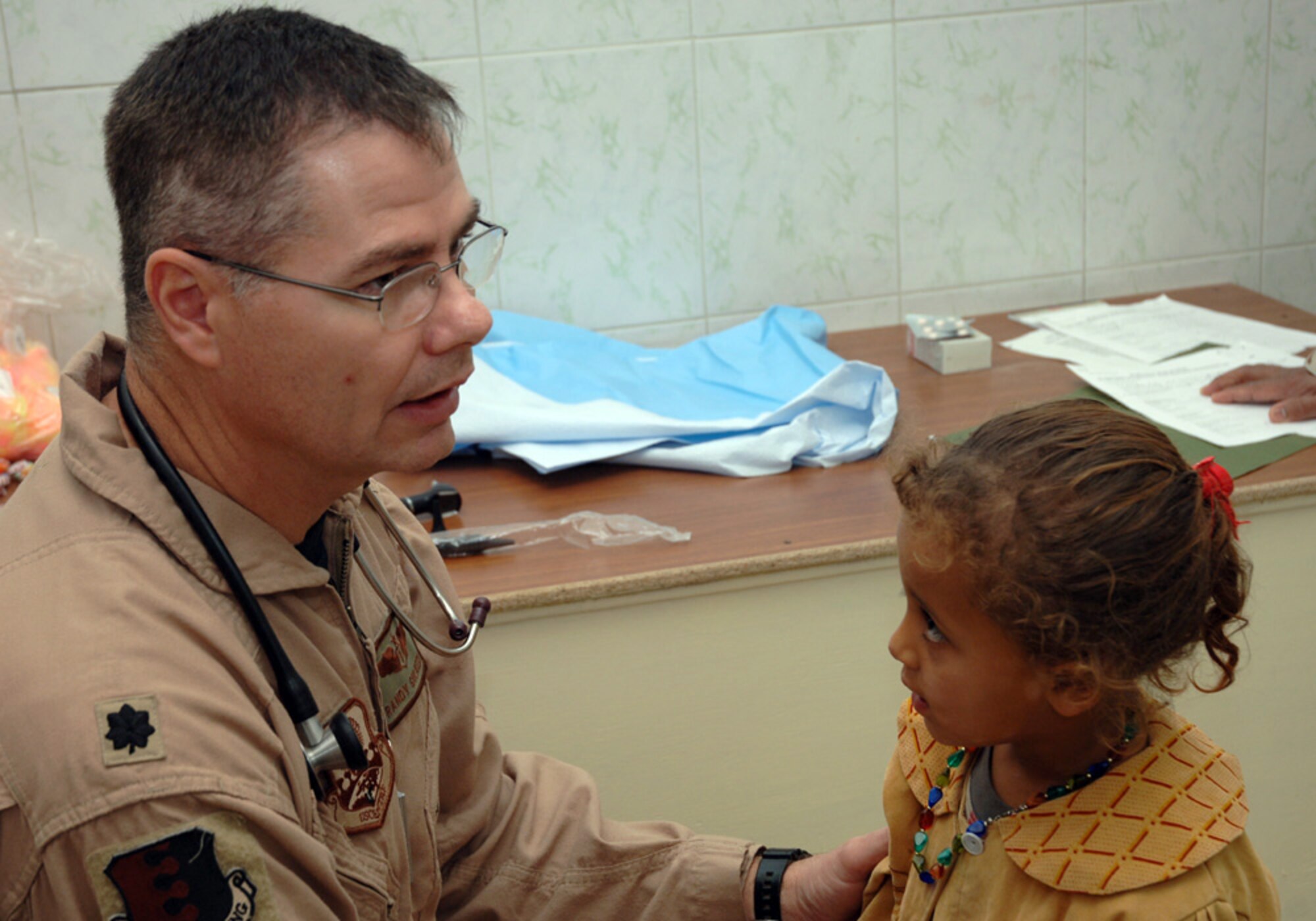 BAGHDAD, Iraq (AFPN) -- Lt. Col. (Dr.) Randy Guliuzza examines a little girl in a clinic here. The colonel is the 447th chief of aerospace medicine.(U.S. Air Force photo by Master Sgt. Randy L. Mitchell)