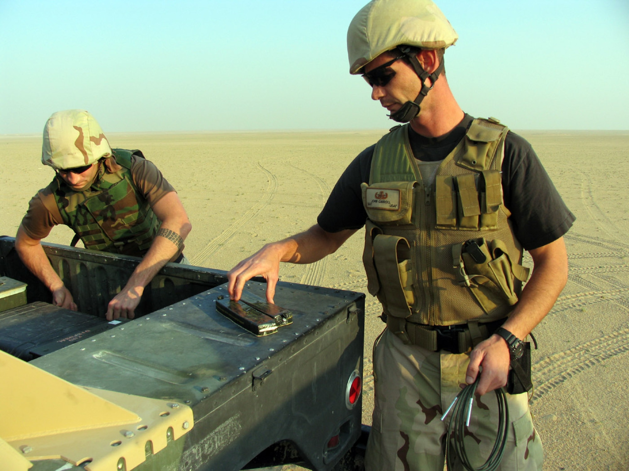 SOUTHWEST ASIA (AFPN) -- Staff Sgt. John Carroll and Senior Airman Gordon Hohman prepare charges to destroy submunitions found in the sand near here. The explosives found are of U.S. design and likely were dropped during the first Gulf War. Sergeant Carroll and Airman Hohman are 386th Explosive Ordnance Disposal technicians. (U.S. Air Force photo by Staff Sgt. Scott Campbell) 