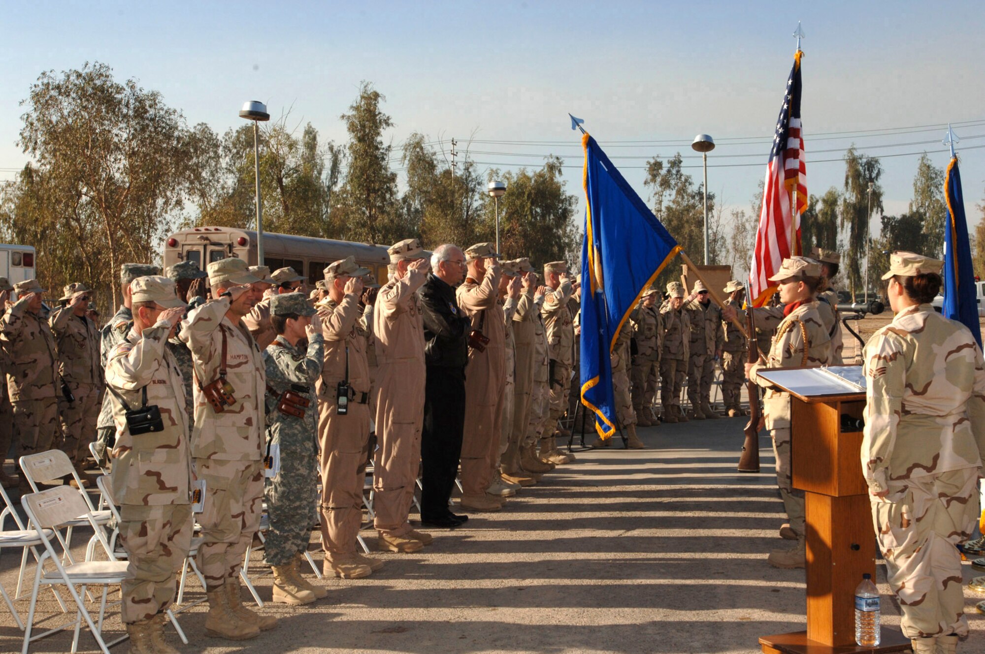 BALAD AIR BASE, Iraq (AFPN) -- Secretary of the Air Force Michael Wynne, along with service members from Balad Air Base and Logistical Support Area Anaconda, pays respect to the flag during the opening of the Contingency Aeromedical Staging Facility. (U.S. Air Force photo by Airman 1st Class Chad Watkins)