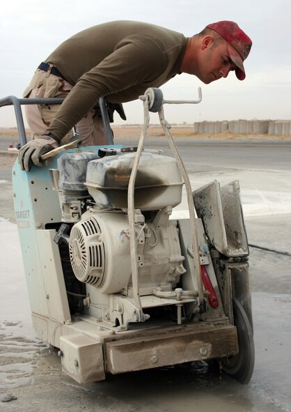 KANDAHAR AIRFIELD, Afghanistan (AFPN) -- Staff Sgt. Matthew Couch cuts a reservoir into the flightline concrete of the flightline as part of a project that will add more than 150,000 square feet of ramp here by early 2006. Sergeant Couch is a pavements and equipment operator with the 1st Expeditionary Red Horse Group (U.S. Air Force photo by Staff Sgt. Marcus McDonald)

