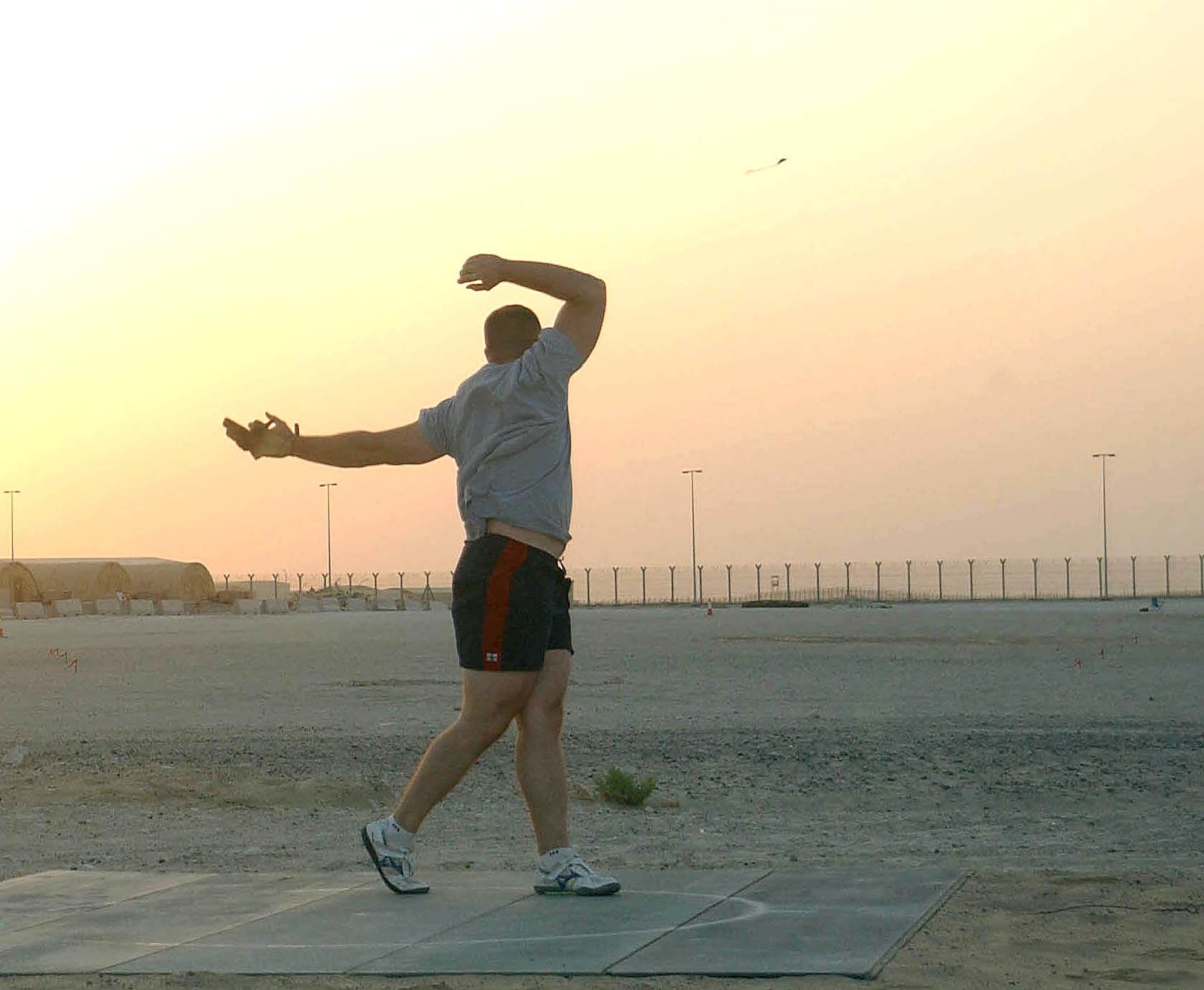 SOUTHWEST ASIA (AFPN) -- The 16-pound steel ball hurtles into the sunset after being released by Capt. James Parker in an open, sandy area at this desert air base recently. The captain regularly practices his sport of the hammer throw in his off-duty time while deployed as deputy commander of the 380th Expeditionary Services Squadron. His goal is to return to the Olympics and finish strongly after competing in the games in 2004 and being named Air Force Athlete of the Year for that year. Captain Parker is deployed from Davis-Monthan Air Force Base, N.M. (U.S. Air Force photo by Tech. Sgt. Mike Hammond)