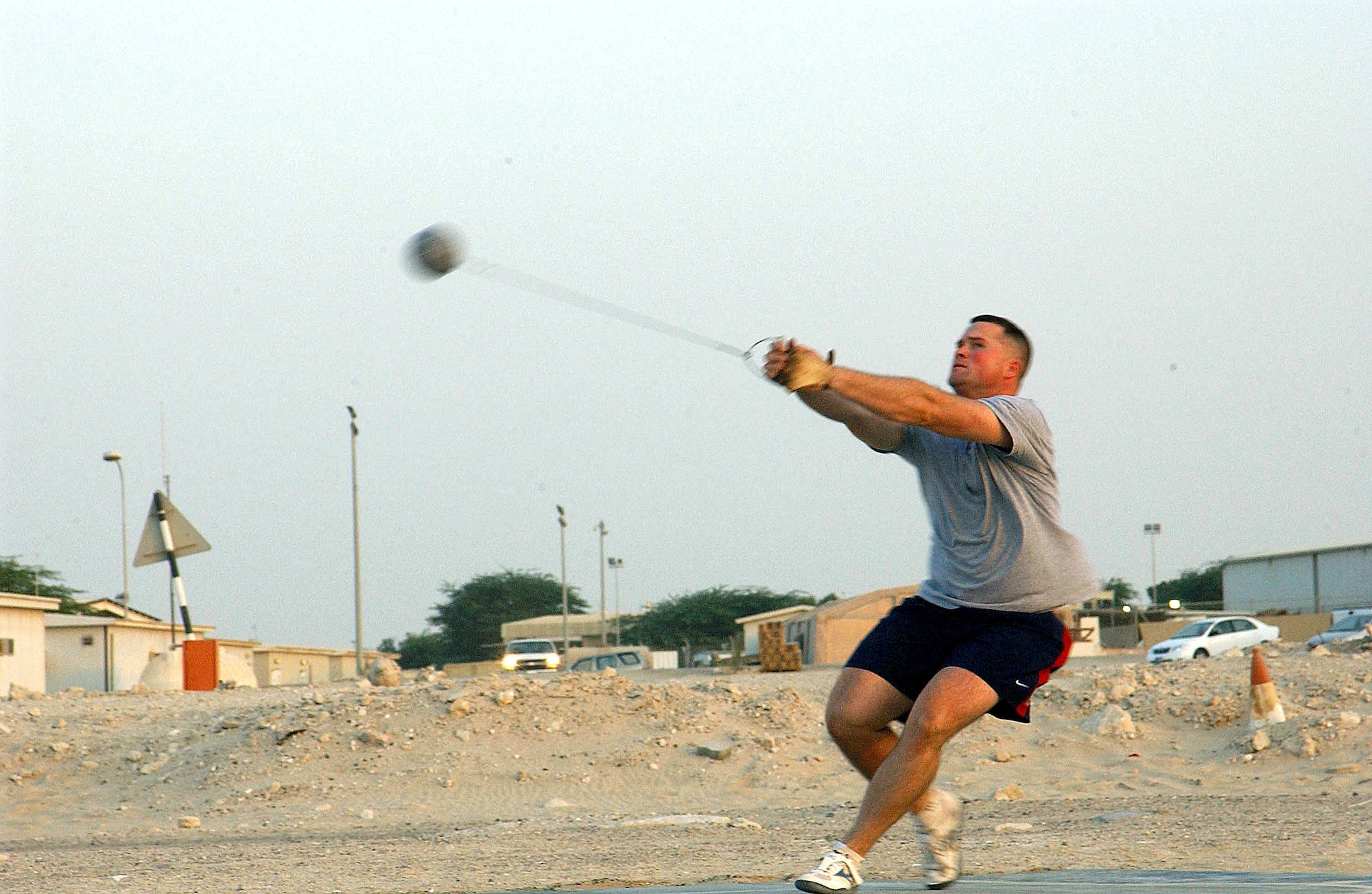 SOUTHWEST ASIA (AFPN) -- Capt. James Parker goes into a spin while practicing the hammer throw at this desert air base recently. The 2004 Air Force Athlete of the Year is the deputy commander of the 380th Expeditionary Services Squadron. By day, he is in charge of activities ranging from the operation of the dining facility to bringing Armed Forces Entertainment opportunities to the troops deployed here. In his off-duty time, the captain trains for a return to the Olympic Games in 2008 after competing there in 2004. He is deployed from Davis-Monthan Air Force Base, Ariz. (U.S. Air Force photo by Tech. Sgt. Mike Hammond) 