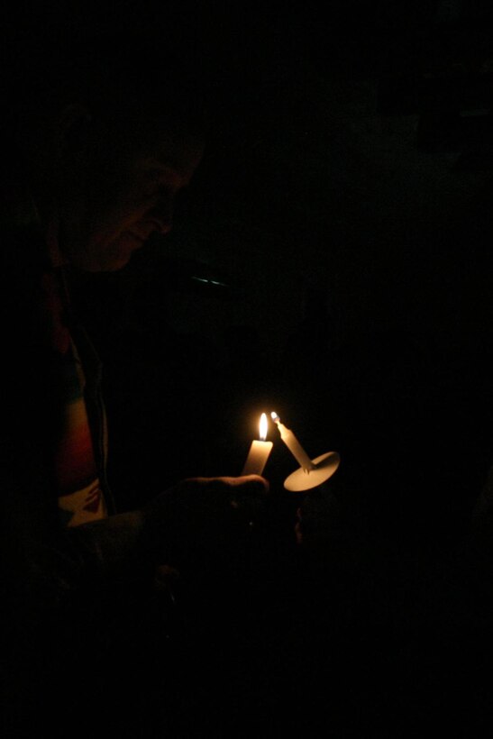 CAMP RIPPER, Iraq ( December 24, 2005)- Regimental Chaplain, Lt. Cmdr. Bradley E. Tellen, 49, lights a candle during  a vigil held at the chapel here. Tellen, a Jacksonville, N.C., native led the hour-long service held on Christmas Eve. (Official U.S. Marine Corps photo by Lance Cpl. Shane S. Keller 2d Marine Division Combat Camera)