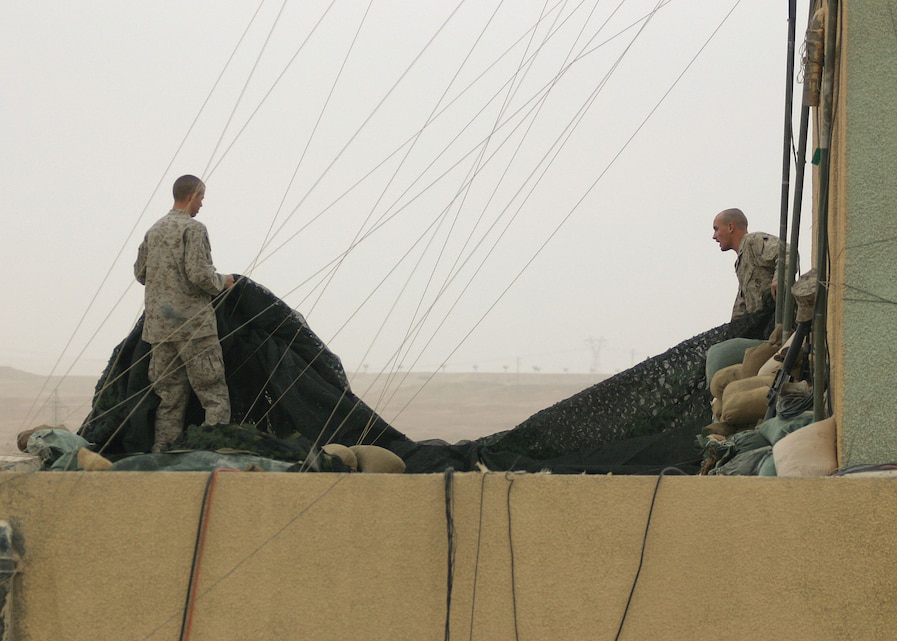 Marines with the 22nd Marine Expeditionary Unit (Special Operations Capable) Command Element set up camouflage netting on a rooftop at Forward Operating Base Hit, Iraq, Dec. 25, 2005. The 22nd MEU (SOC) is in Iraq supporting Operation Iraqi Freedom.