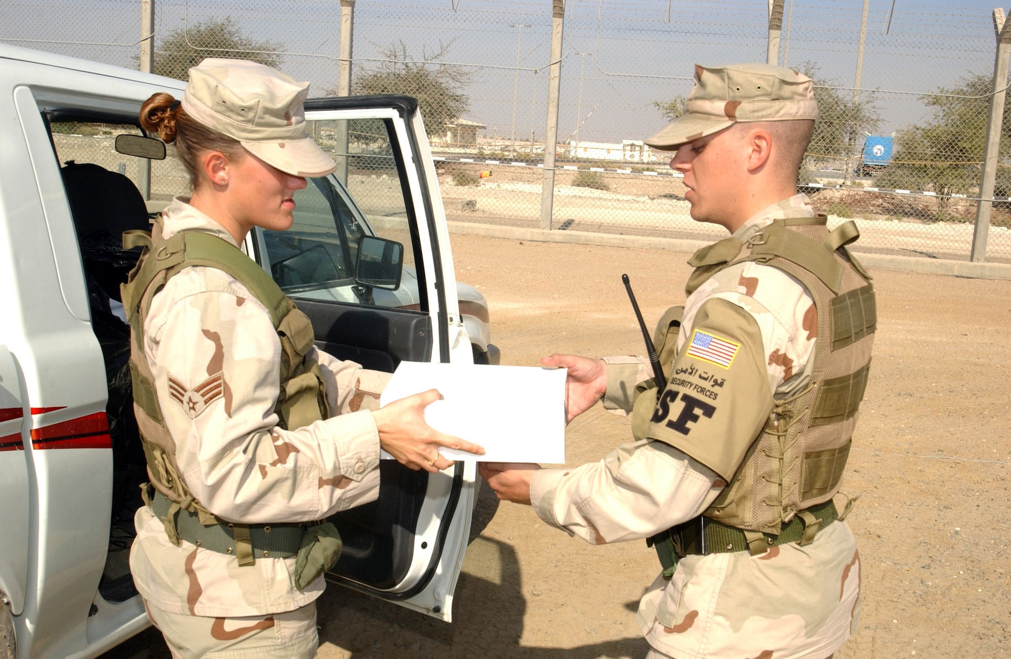SOUTHWEST ASIA (AFPN) -- Senior Airman Amber Sigler delivers a box lunch to Airman 1st Class Richard Straut at a guard tower on Christmas Eve.  Airman Sigler is deployed here from the 436th Security Forces Squadron at Dover Air Force Base, Del., and Airman Straut from the 52nd Security Forces Squadron at Spangdahlem Air Force Base, Germany.    (U.S. Air Force photo by Tech. Sgt. Mike Hammond)