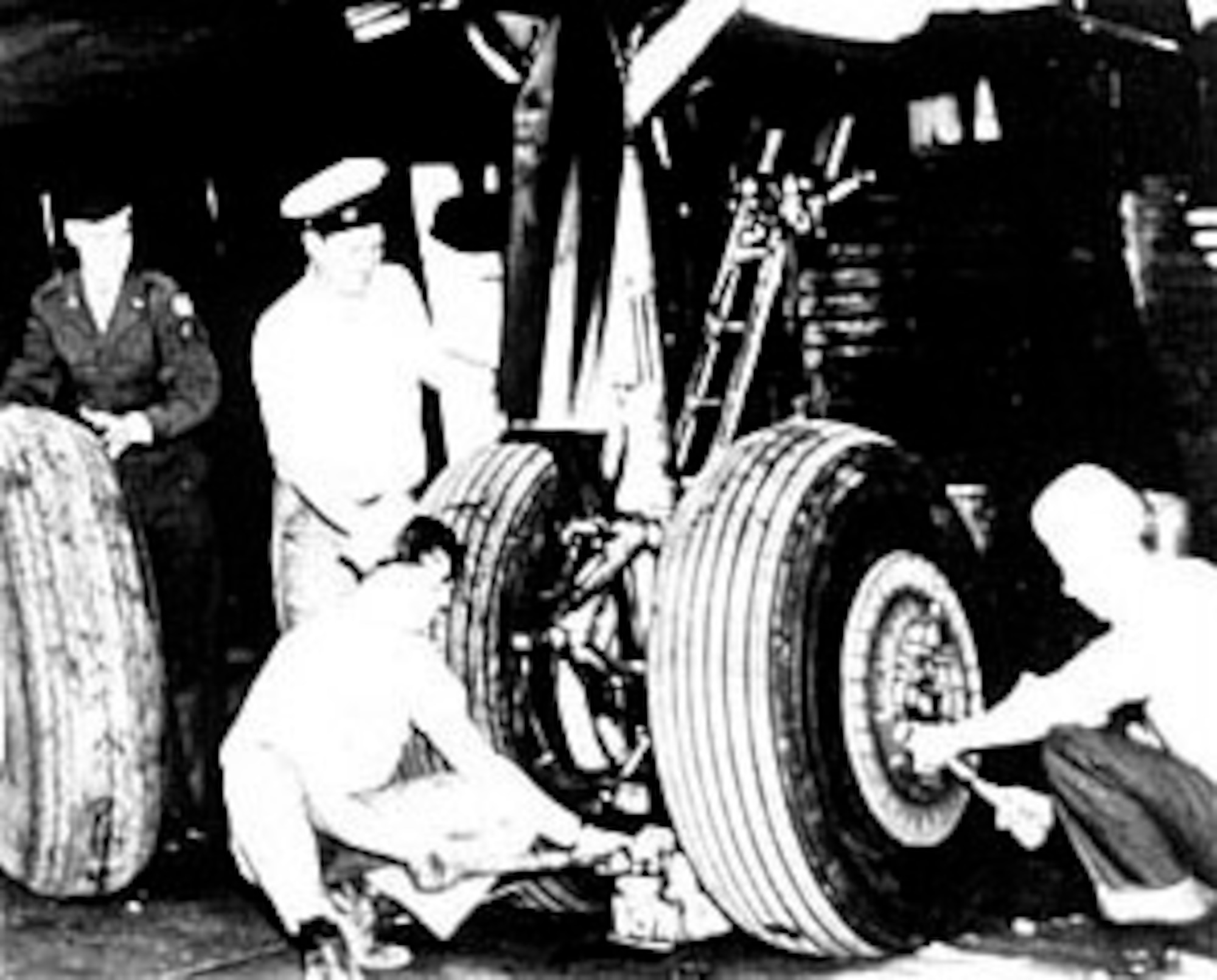 U.S. Navy support personnel from VR-6, assisted by an Air Force enlisted man, change a tire on a Navy R-5D (C-54). (U.S. Air Force photo)