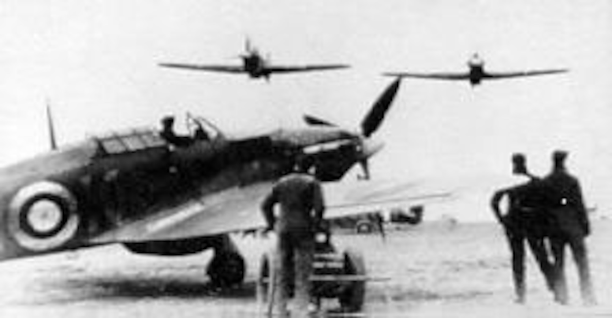 Two Eagle Squadron Hurricanes make a low pass over a third on the tarmac. (U.S. Air Force photo)