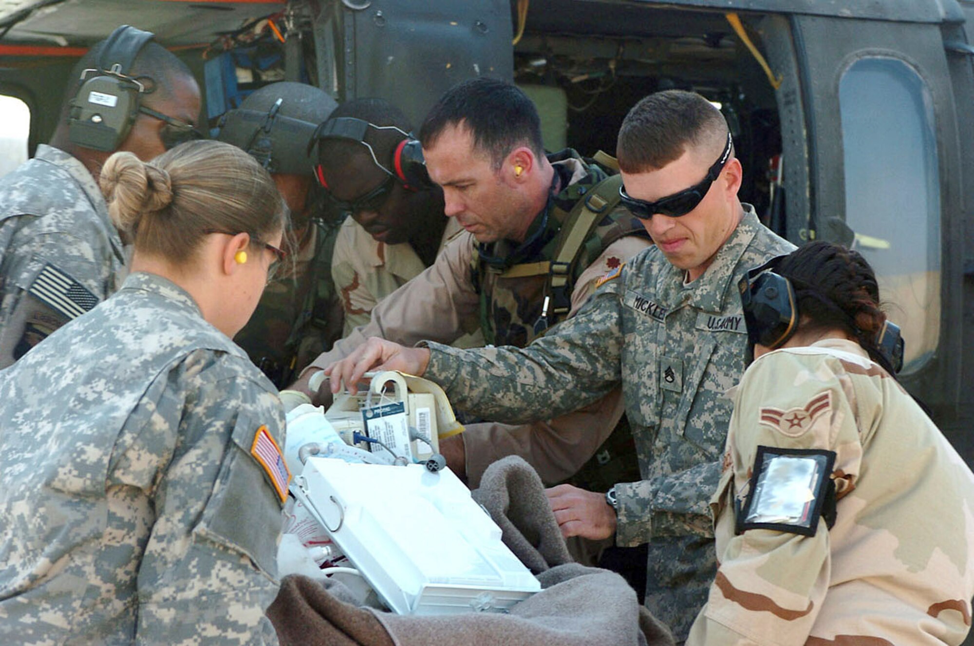 BALAD AIR BASE, Iraq (AFPN) -- Airmen and Soldiers unload a patient from a helicopter at the Air Force theater hospital here. Service members who are wounded in Iraq and need to be medically evacuated come to this hospital. (U.S. Army photo by Sgt. Dallas Walker)