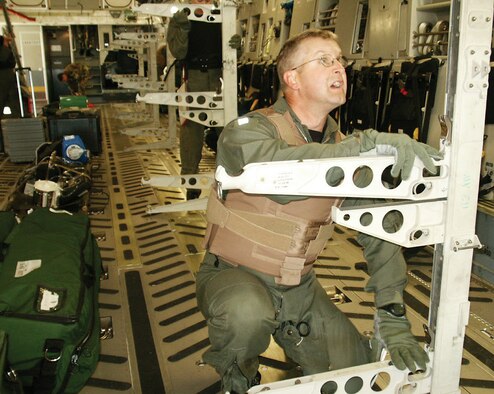 Capt. Barry Van Sickle, 446th Aeromedical Evaucation Squardon, secures stanchions on a C-17. Stanchions are used to support patient litters on aeromedical flights