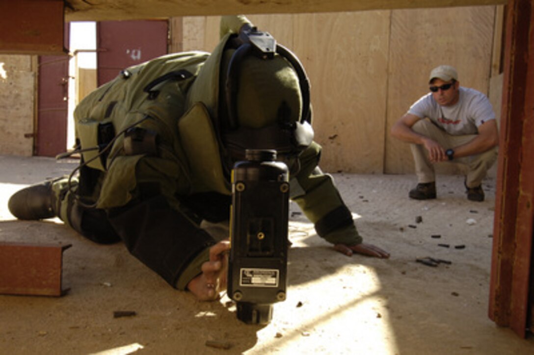 Navy Chief Petty Officer Zach Holzhausen (right) watches a member of the Yemen Explosive Ordnance Disposal team place a portable X-ray machine near a simulated improvised explosive device during training in Sana'a, Yemen, on Dec. 18, 2005. Members of the U.S. Navy's EOD team attached to the Combined Joint Task Force-Horn of Africa from Camp Lemonier, Djibouti, are training with members of Yemen's Ministry of the Interior EOD team. 