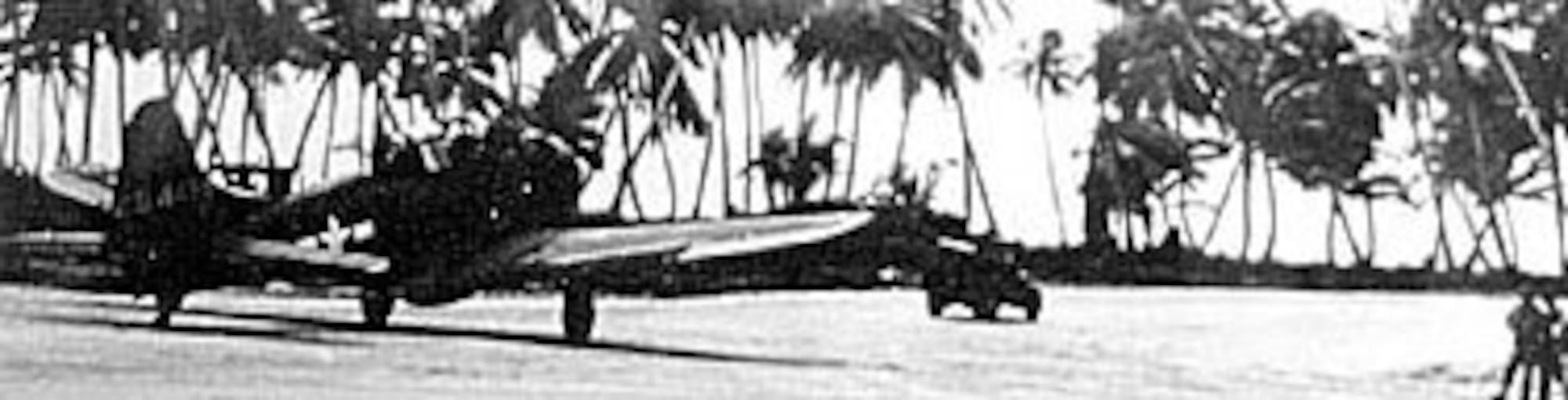 A jeep leads a Douglas A-24 dive bomber to the dispersal area on Makin Island in December 1943. (U.S. Air Force photo)