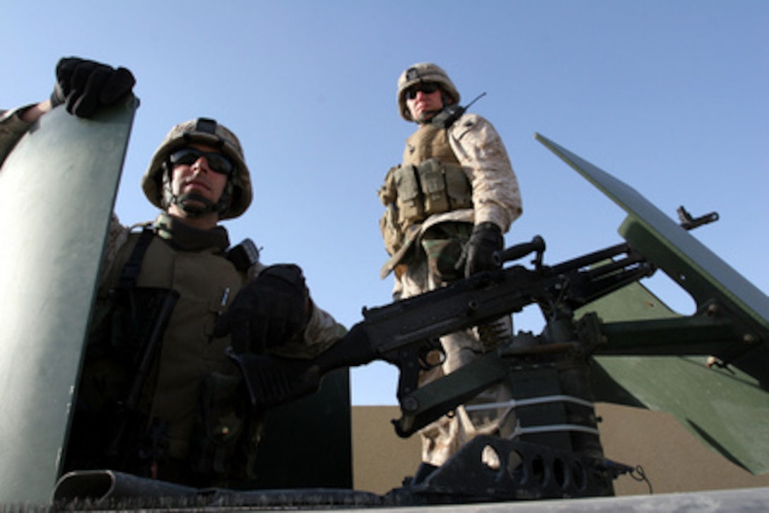 U.S. Marines of Military Transition Team 7 provide perimeter security while Iraqi soldiers hunt for a weapons cache at the Jolan Cemetery in Falujah, Iraq, on Dec. 24, 2005. Soldiers from the 1st Iraqi Infantry Division, 2nd Brigade, 2nd Battalion broadened the search after finding weapons hidden on the grounds. 