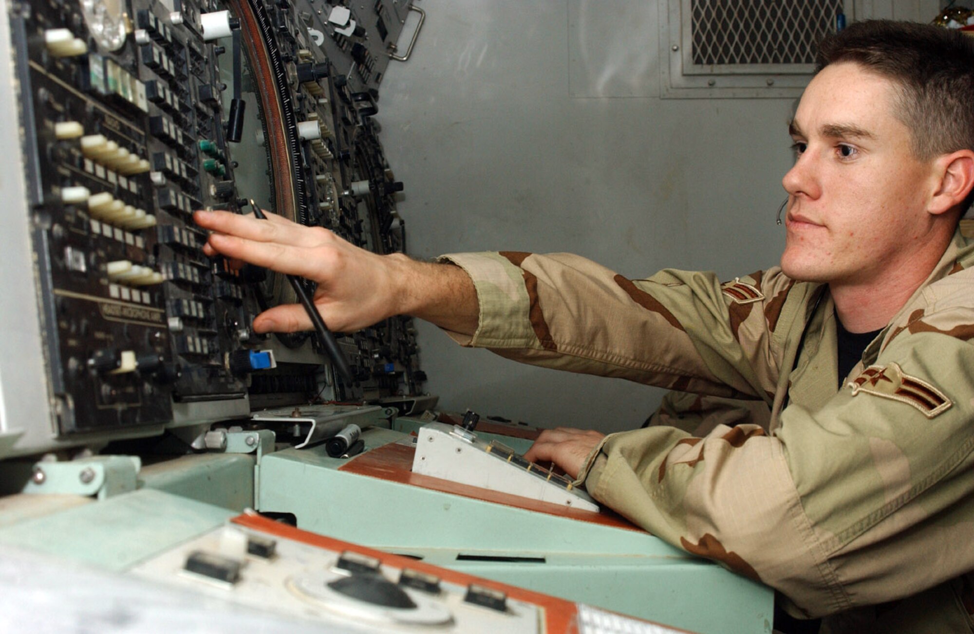 ALI BASE, Iraq (AFPN) -- Air traffic controllers Airman 1st Class Grant Gers -- monitoring radio traffic -- is one of the Airmen who helps monitor air traffic over Iraq. A small group of Airmen from the 407th Expeditionary Operations Support Squadron's Area Control Center control the southern third of Iraqi skies. The Airmen use a highly mobile radar unit to cover the 50,000 square miles. (U.S. Air Force photo by Tech. Sgt. Paul Dean)