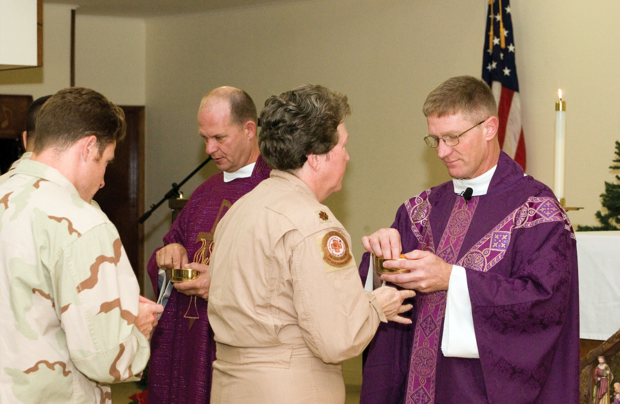 SOUTHWEST ASIA (AFPN) -- Chaplain (Lt. Col.) David Reeson and Chaplain (Maj.) Robert Barnhill perform communion during Catholic mass at the 379th Air Expeditionary Wing Victory Chapel here. (U.S. Photo by Master Sgt. Stanley Coleman)
