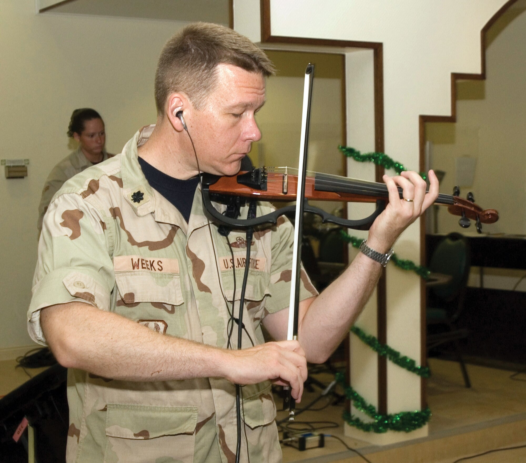 SOUTHWEST ASIA (AFPN) -- Lt. Col. Michael Weeks plays the violin for the contemporary service at the 379th Air Expeditionary Wing's Victory Chapel here. "Performing with the Praise Band is a great way to worship God," he said. The colonel is a plans officer at the this base's combined air operations center. (U.S. Air Force photo by Master Sgt. Stanley Coleman)