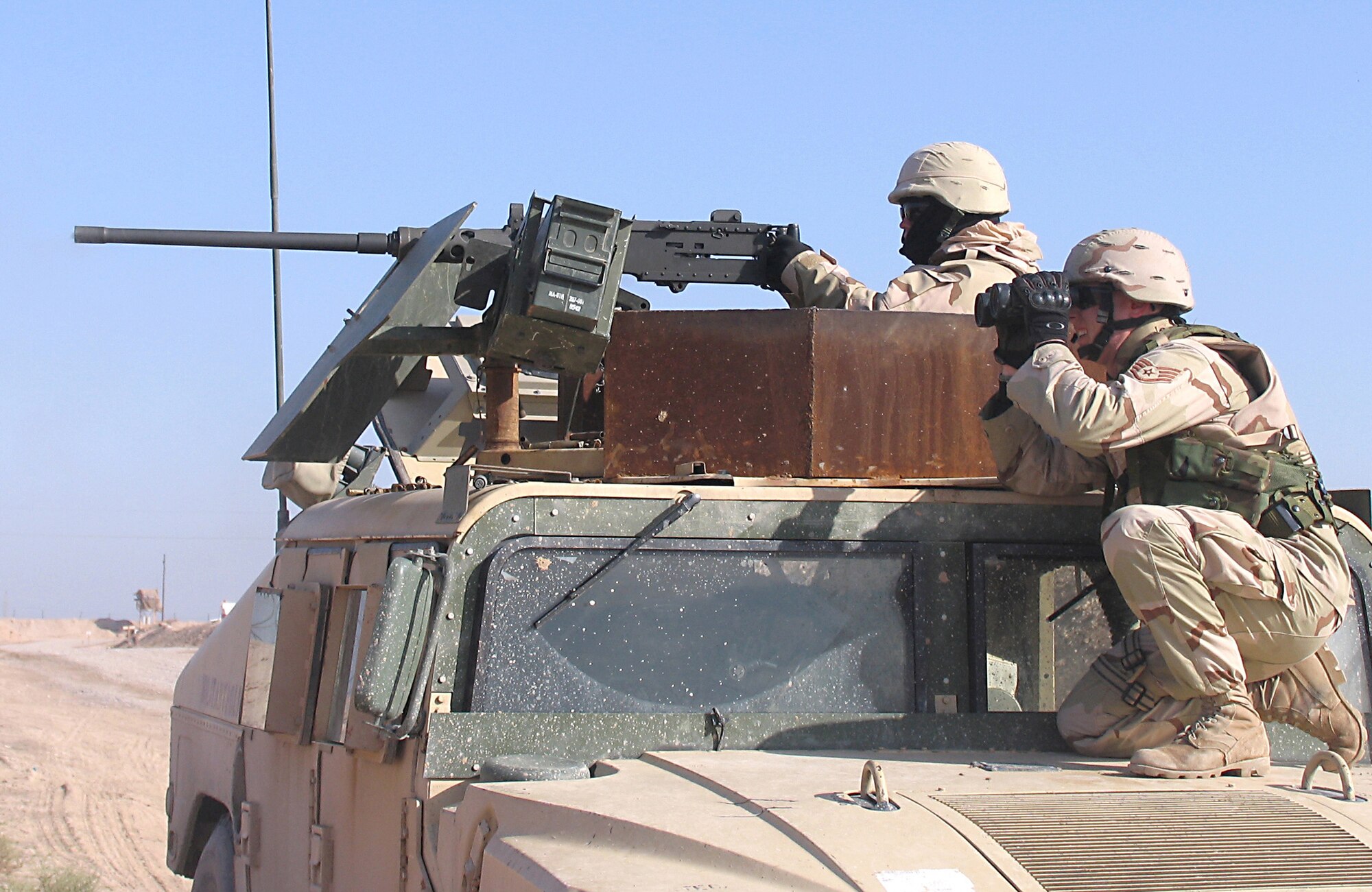 CAMP BUCCA, Iraq -- Staff Sgt. Frank Woznick, right, checks the accuracy of .50-caliber machine gun fire by Senior Airman Jeffrey Polzin. The security forces troops were conducting a live-fire test here. They are responsible for base defense, force protection and convoy security here.  (U.S. Air Force photo by Capt. Michael G. Johnson)