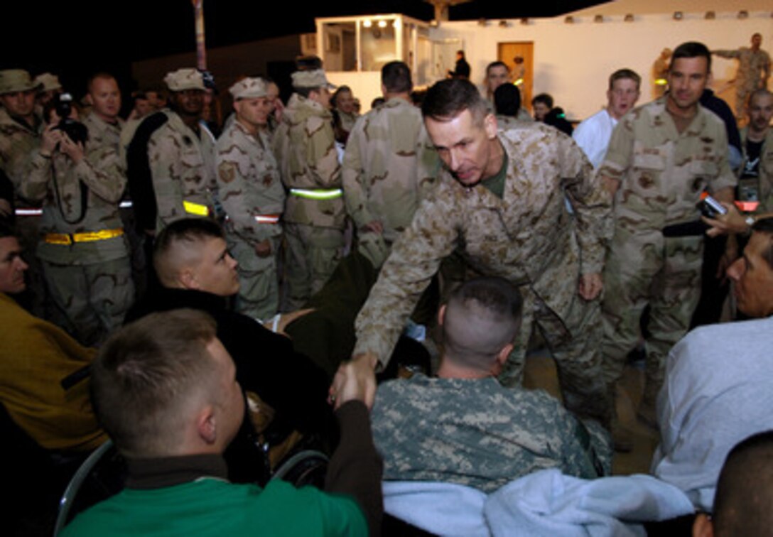 Chairman of the Joint Chiefs of Staff Gen. Peter Pace, U.S. Marine Corps, greets wounded soldiers at an air base near Doha, Qatar, on Dec. 28, 2005. A USO-sponsored troupe including 2004 American Idol finalist Diana DeGarmo, country music star Michael Peterson and comedian and actor Reggie McFadden accompanied Pace as he visits troops deployed during the holiday season. 