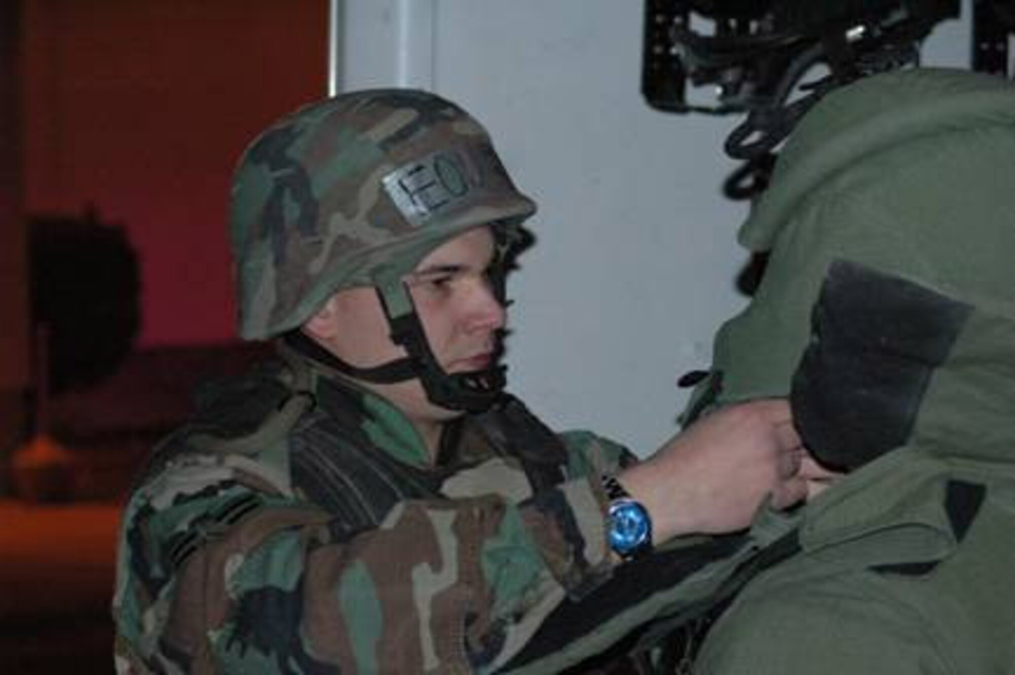 Senior Airman John Broussard helps Airman 1st Class Nicholas Worthington, both from Explosive Ordnance Disposal, put on a bomb suit before investigating a suspicious bag in the East Fitness Center here. (Air Force photo)

