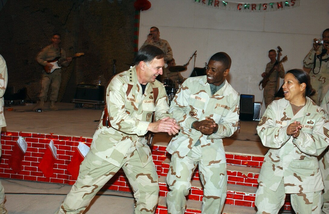 ALI BASE, Iraq (AFPN) -- The U.S. Air Forces in Europe Touch and Go Band had the base "Big Top" hopping and Airmen dancing in the aisles. Gen. William T. "Tom" Hobbins (left) joined in, sharing an impromptu dance with Staff Sgt. Christopher Berry and Tech. Sgt. Marina Moore. General Hobbins is the USAFE commander. Sergeant Berry is deployed to the 407th Expeditionary Communications Squadron and Sergeant Moore to 407th Expeditionary Services Squadron. (U.S. Air Force photo by Tech. Sgt. Paul Dean)