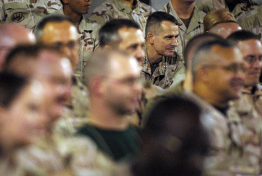 Chairman of the Joint Chiefs of Staff Gen. Peter Pace, U.S. Marine Corps, sits in the audience of airmen at Al Dhafra Air Base, United Arab of Emirates, during a USO show on Dec. 29, 2005. Pace is in the Persian Gulf region to visit troops deployed during the holiday season. A USO- sponsored troupe including 2004 American Idol finalist Diana DeGarmo, country music star Michael Peterson and comedian and actor Reggie McFadden is traveling with Pace. 