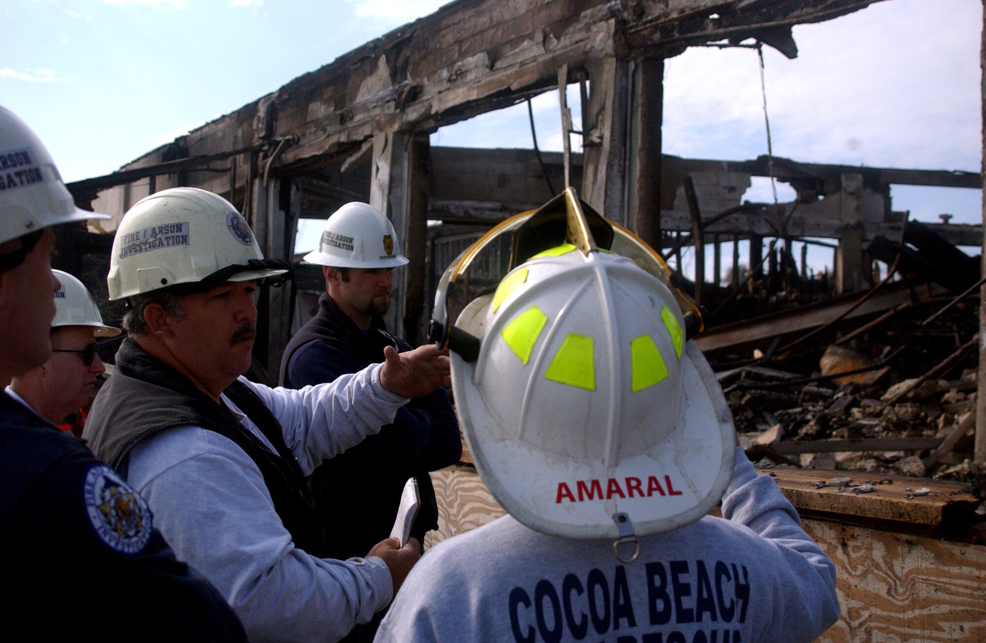 PATRICK AIR FORCE BASE, Fla. -- Murray McDonald discusses the structural damage and immediate fire assessment of the officers club here with his colleagues from the State Fire Marshal division.  The cause of the blaze is still under investigation.  Mr. McDonald is a law enforcement detective.  (U.S. Air Force photo by 1st Lt. Elizabeth Kreft)