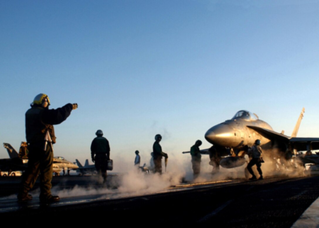 U.S. Navy sailors and Marines perform final checks before launching an F/A-18A Hornet from one of four steam powered catapults on the flight deck of the aircraft carrier USS Harry S. Truman (CVN 75) on Jan. 24, 2005. Truman and embarked Carrier Air Wing 3 are providing close air support and conducting intelligence, surveillance and reconnaissance missions over Iraq. The Hornet is assigned to the Marine Strike Fighter Squadron 115. 