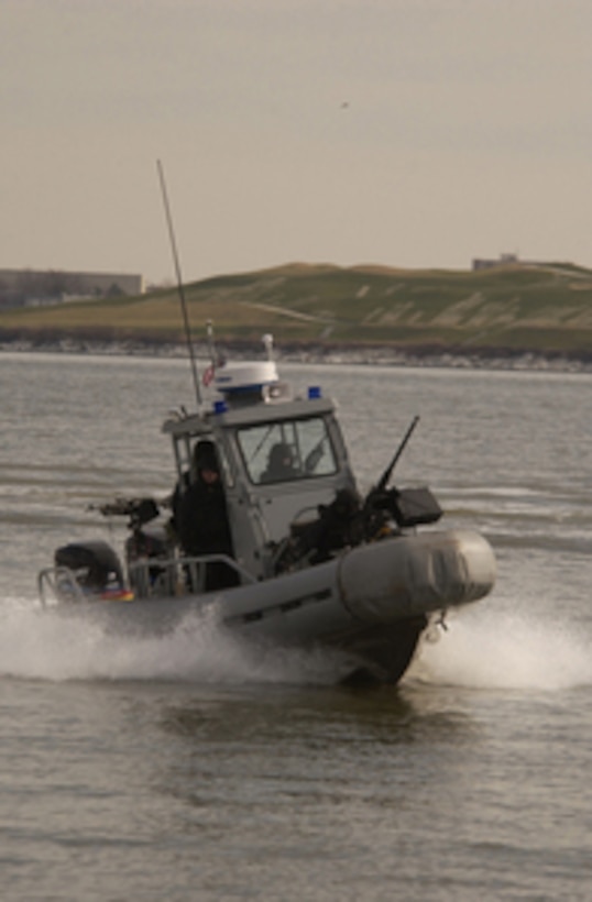A Navy small craft patrols the exclusion area of the harbor in Portsmouth, Va., during a simulated small boat attack scenario on Jan. 25, 2005. The small craft is assigned to Mobile Security Detachment 24, a new unit created to defend U.S. costal assets at home and abroad. 