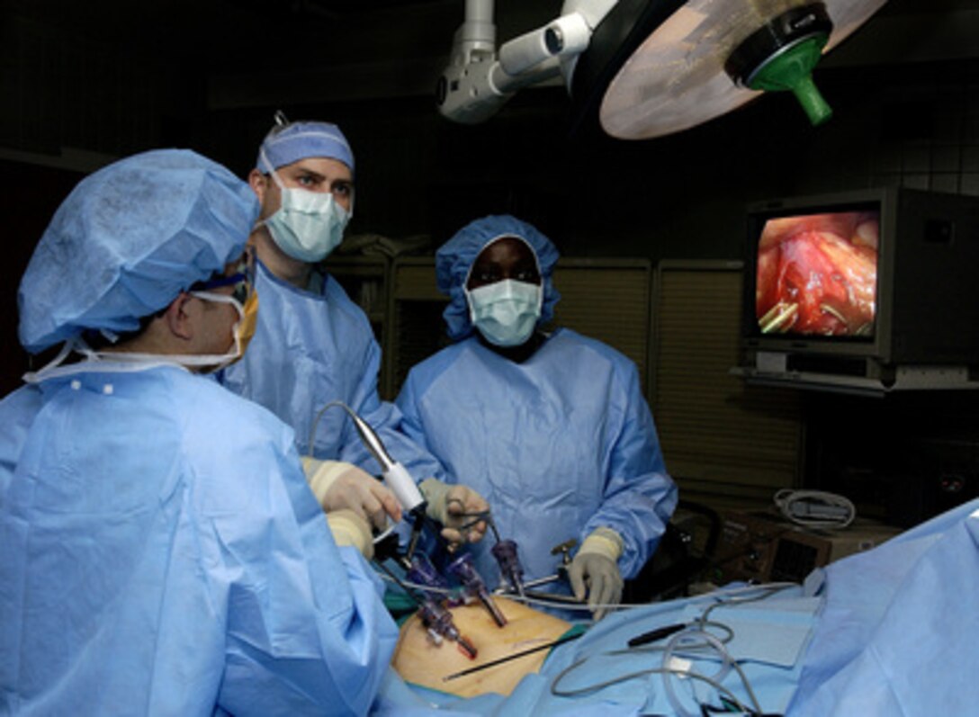 Doctors Ronald Post (left) and John Smear (center) and Physician's Assistant Debra Blackshire perform laparoscopic stomach surgery at Langley Air Force Base, Va., on Jan. 31, 2005. The surgery will involve the removal of the gall bladder to help alleviate acid reflux disease. 