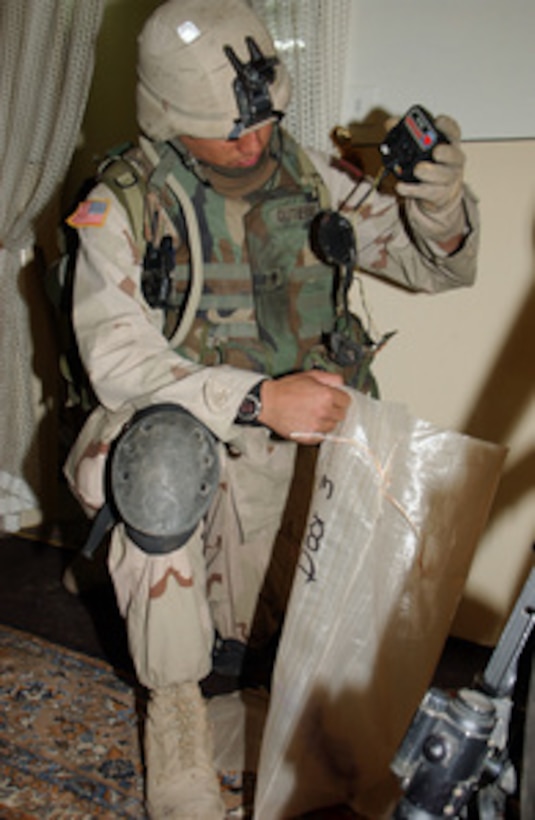 U.S. Army Spc. Gutierrez puts items used to make improvised explosive devices into a plastic sack for transport out of the apartment it was found in on Jan. 20, 2005, in Bayji, Iraq. The apartment complex is being searched for weapons or bomb- making materials by members of 3rd Platoon, C Battery, 1st Battalion, 7th Field Artillery Regiment, 2nd Brigade, 1st Infantry Division. 