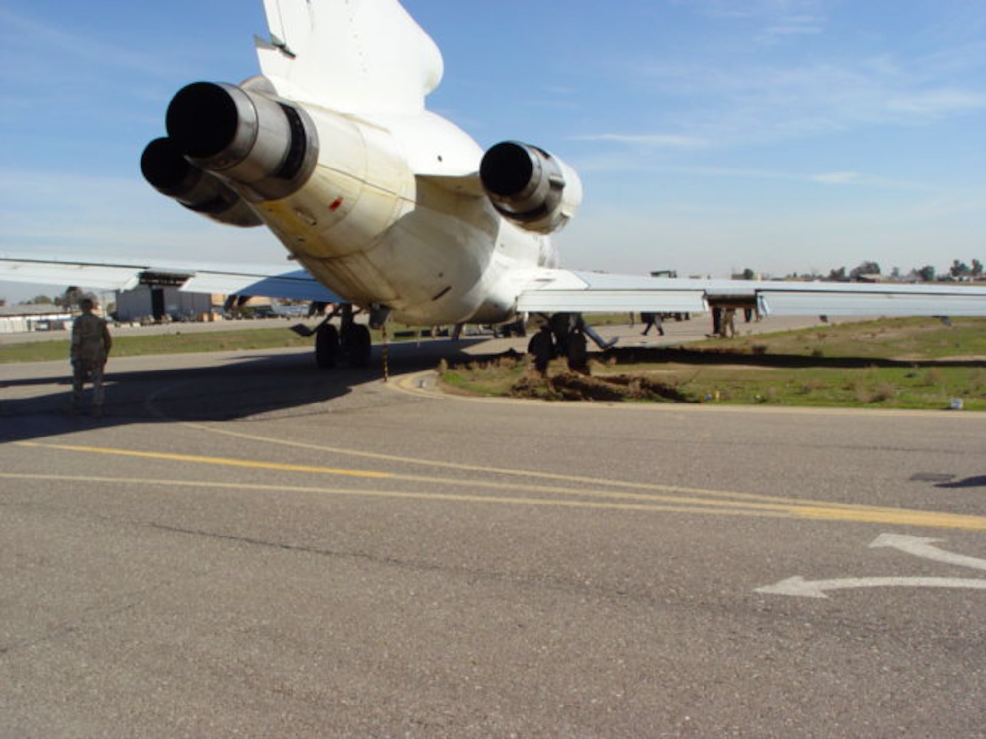 KIRKUK AIR BASE, Iraq -- Airmen here survey a mail cargo plane that turned too soon and became mired in the mud.  The aircraft was stuck between two taxiways while Airmen spent more than 40 hours removing it.  (U.S. Air Force photo by Staff Sgt. Matthew Lohr)