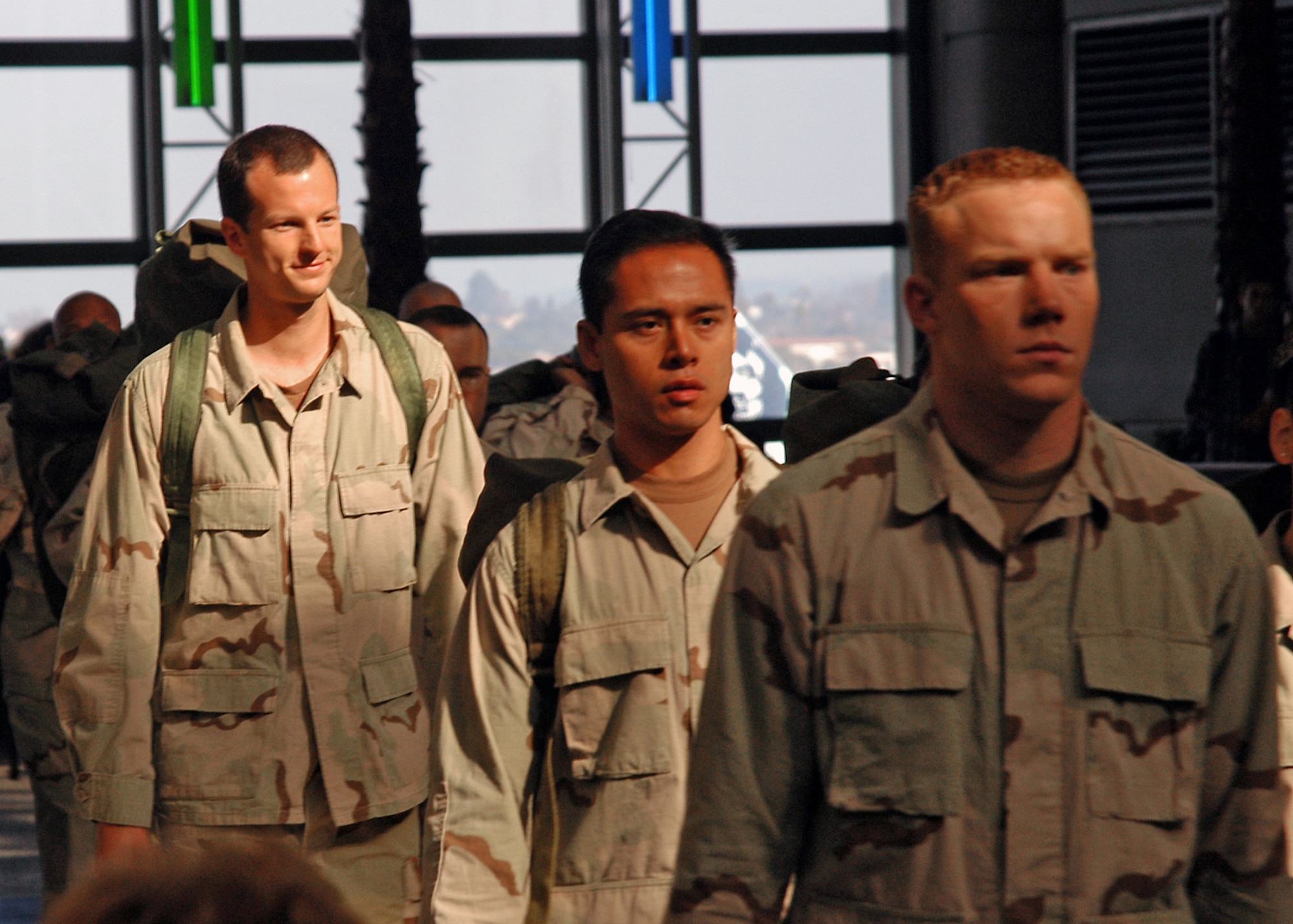 LOS ANGELES -- First Lt. Jeff McGowan, left, and several other servicemembers walk along a concourse in the international terminal at Los Angeles International Airport during the filming of a commercial scheduled to air during the Super Bowl.  Lieutenant McGowan is an engineer at the Space and Missile Systems Center at nearby Los Angeles Air Force Base.  (U.S. Air Force photo by Jason M. Webb)