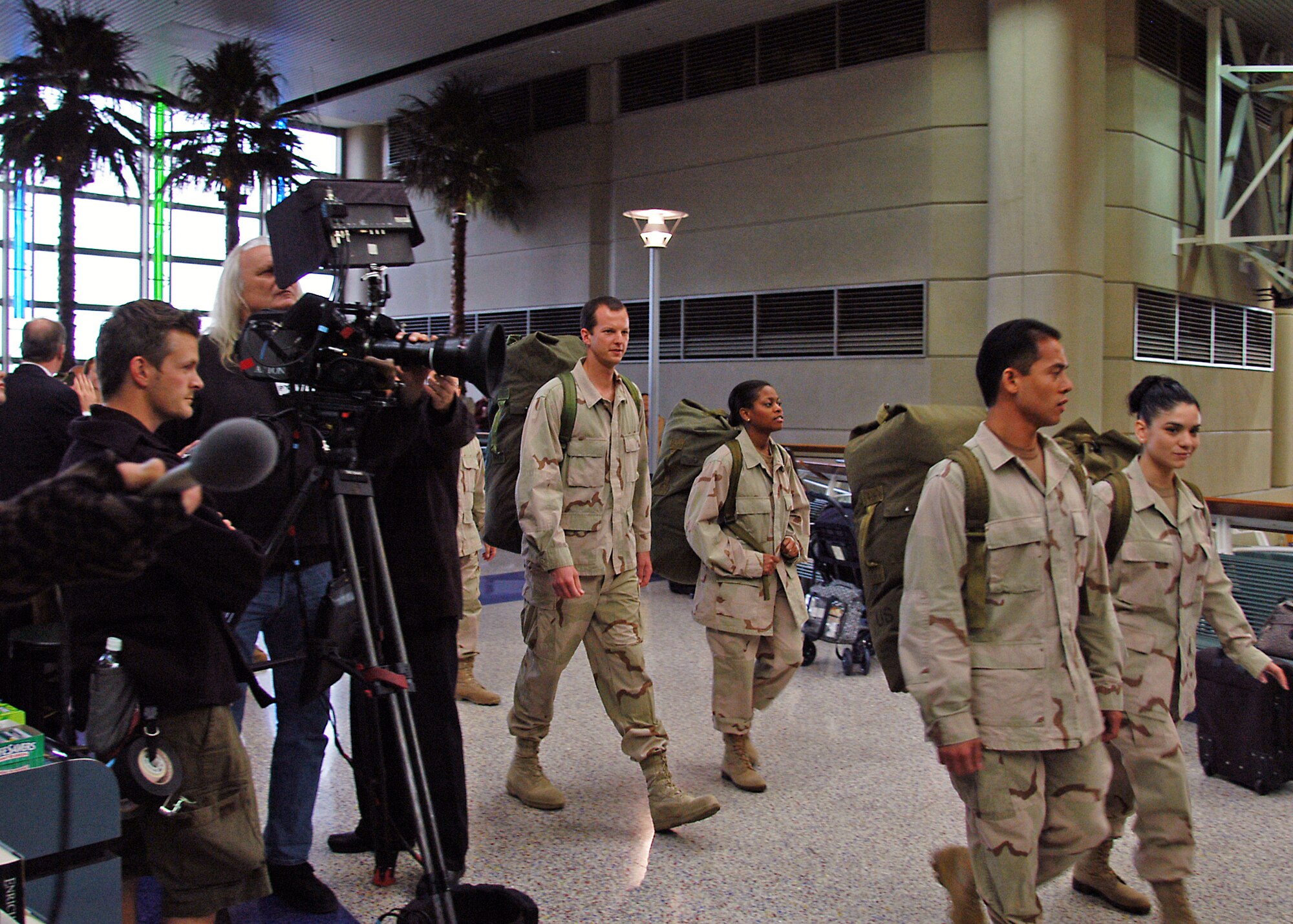 LOS ANGELES -- First Lt. Jeff McGowan, center, enters the international terminal at Los Angeles International Airport with other servicemembers during the filming of a commercial scheduled to air during the Super Bowl.   Lieutenant McGowan is an engineer at the Space and Missile Systems Center at nearby Los Angeles Air Force Base.  (U.S. Air Force photo by Jason M. Webb)