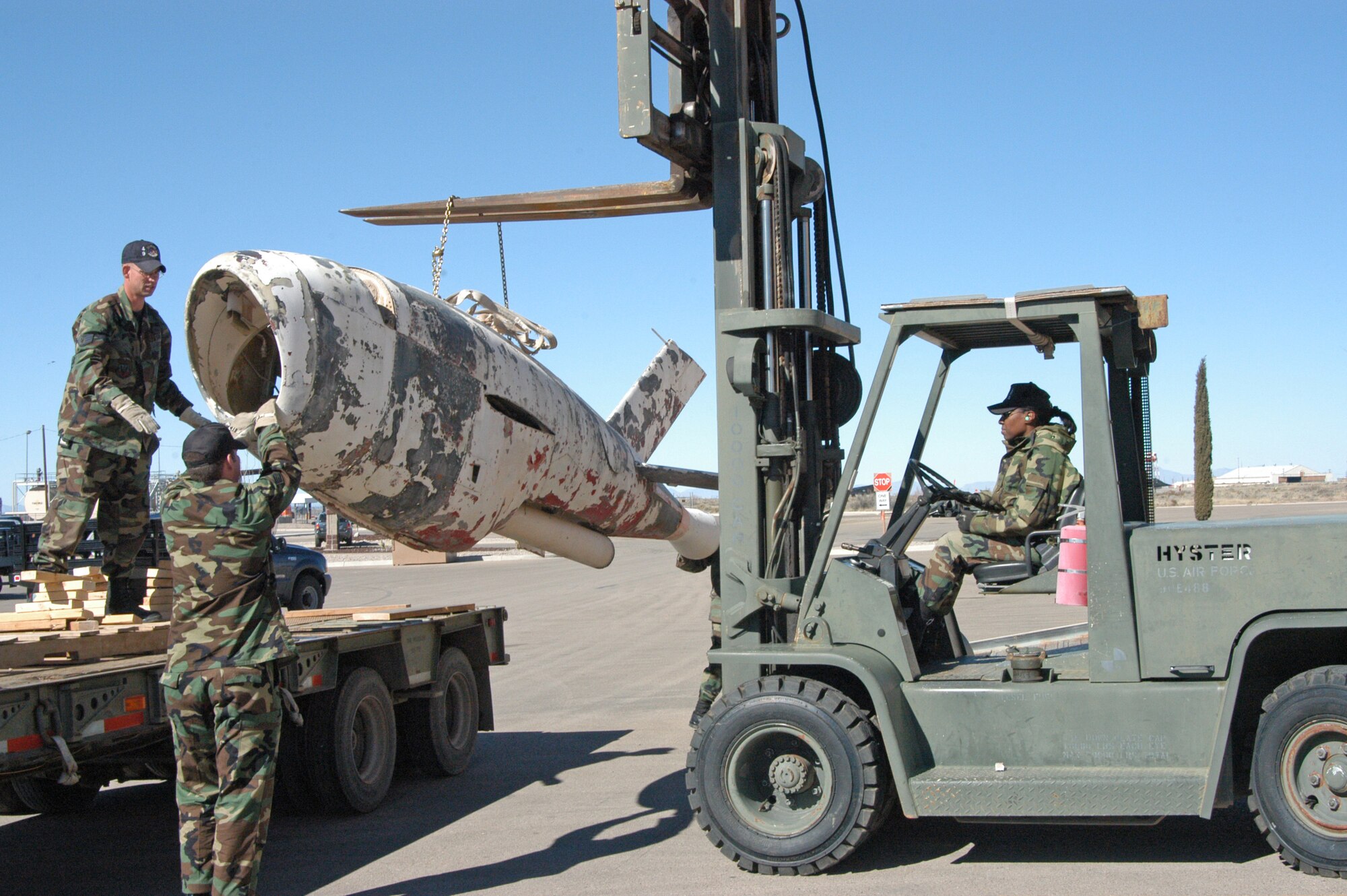 HOLLOMAN AIR FORCE BASE, N.M. -- (From left) Staff Sgt. Marc Long, Tech. Sgt. Nolverto Nieto and Senior Airman Tonia Rybarczyk remove a Q-2 Firebee drone from a flatbed trailer Jan. 28.   The drone will be stored here until an aircraft can take it to the National Museum of the U.S. Air Force at Wright-Patterson Air Force Base, Ohio, where it will be restored and displayed.  (U.S. Air Force photo by Laura Hunt) 