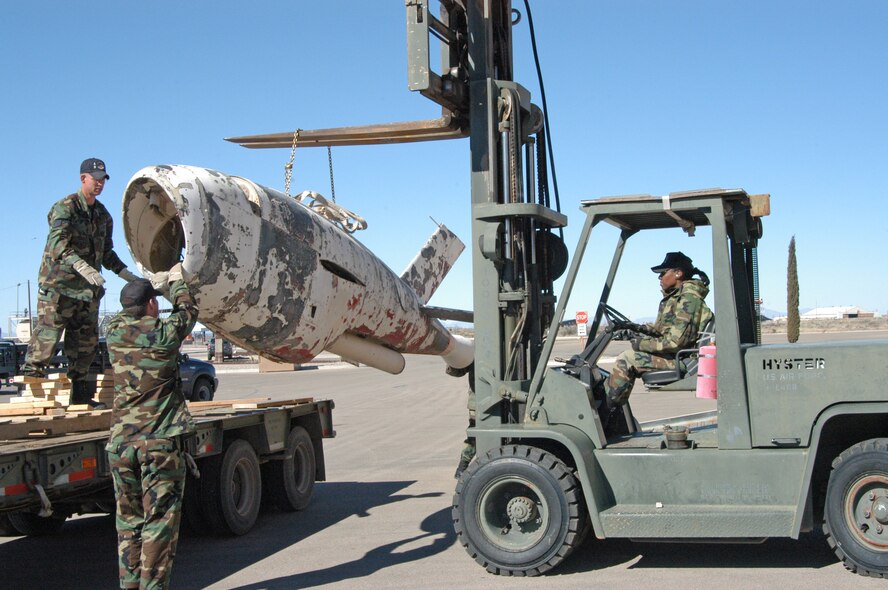 HOLLOMAN AIR FORCE BASE, N.M. -- (From left) Staff Sgt. Marc Long, Tech. Sgt. Nolverto Nieto and Senior Airman Tonia Rybarczyk remove a Q-2 Firebee drone from a flatbed trailer Jan. 28.   The drone will be stored here until an aircraft can take it to the National Museum of the U.S. Air Force at Wright-Patterson Air Force Base, Ohio, where it will be restored and displayed.  (U.S. Air Force photo by Laura Hunt) 