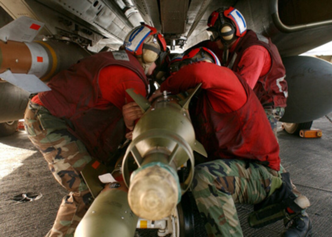 Navy Aviation Ordnancemen work together to mount Laser Guided Bombs underneath an F-14B Tomcat during combat preparations on the flight deck of the aircraft carrier USS Harry S. Truman (CVN 75) on Feb. 1, 2005. Aircraft from Carrier Air Wing 3 embarked on the Truman are providing close air support and conducting intelligence, surveillance and reconnaissance missions during operations in the Persian Gulf. 
