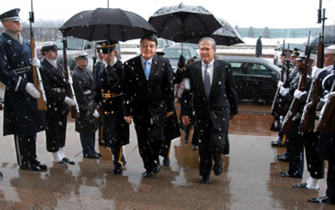Secretary of Defense Donald H. Rumsfeld (right) escorts Bulgarian Minister of Defense Nikolai Svinarov (center) through an honor cordon and into the Pentagon on a snowy Feb. 3, 2005. Rumsfeld and Svinarov will meet to discuss a range of bilateral security issues. 