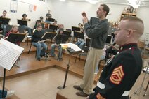 After sharing with them the opportunities for musicians in the Marine Corps, Gunnery Sgt. William R. Howe listens to the North High School band perform Feb. 7, 2005, in Des Moines, Iowa. Howe oversees the Musical Enlistment Option Program, which allows high school musicians to join the Marines and play in one of its 13 bands. Howe auditions students throughout the 9th Marine Corps District in order to fill approximately two dozen spots each year. Howe is a 35-year-old native of Davie, Fla. (Photo by Staff Sgt. Bill Lisbon)
