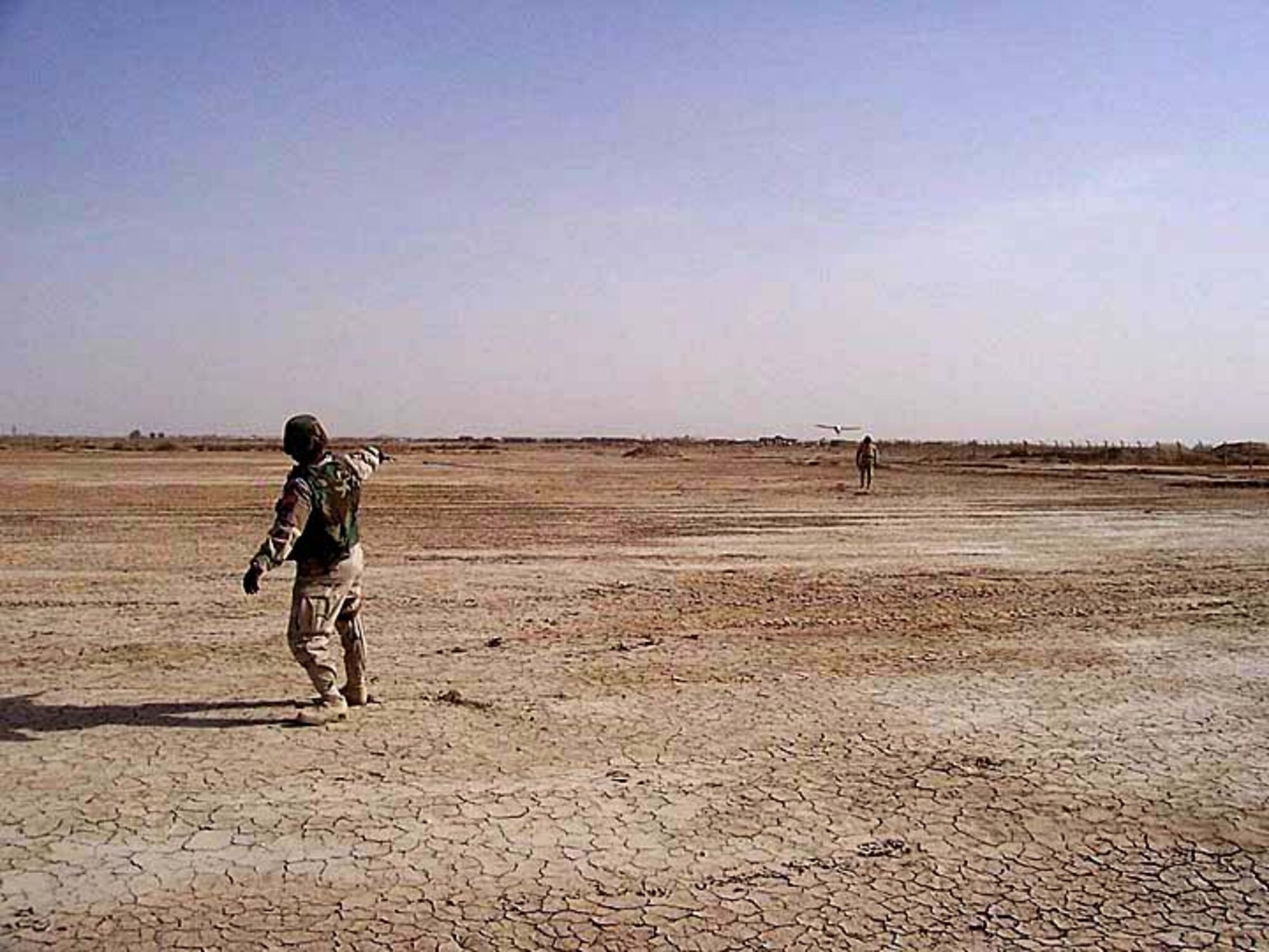 TALLIL AIR BASE, Iraq -- Master Sgts. John Jackson (Left) and Tyrone McKay launch a Desert Hawk here.  The Desert Hawk is a miniature unmanned aerial vehicle used by security forces to see beyond base perimeters providing a rapid assessment of threats.  (Courtesy photo)