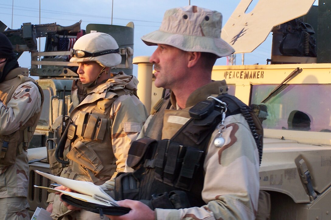 CAMP FALLUJAH, Iraq ? Equipment Operator 2nd Class Ken Langdon listens as Steelworker Chief Charles Becker delivers an early morning convoy brief. Langdon and Becker are assigned to the Naval Mobile Construction Battalion 23 (NMCB-23) Tactical Movement Team. The TMT team, a Seabee Task Force deployed in support of I MEF,  has been conducting daily missions into Fallujah since late last year, on the heels of some of the fiercest fighting since the war?s onset.