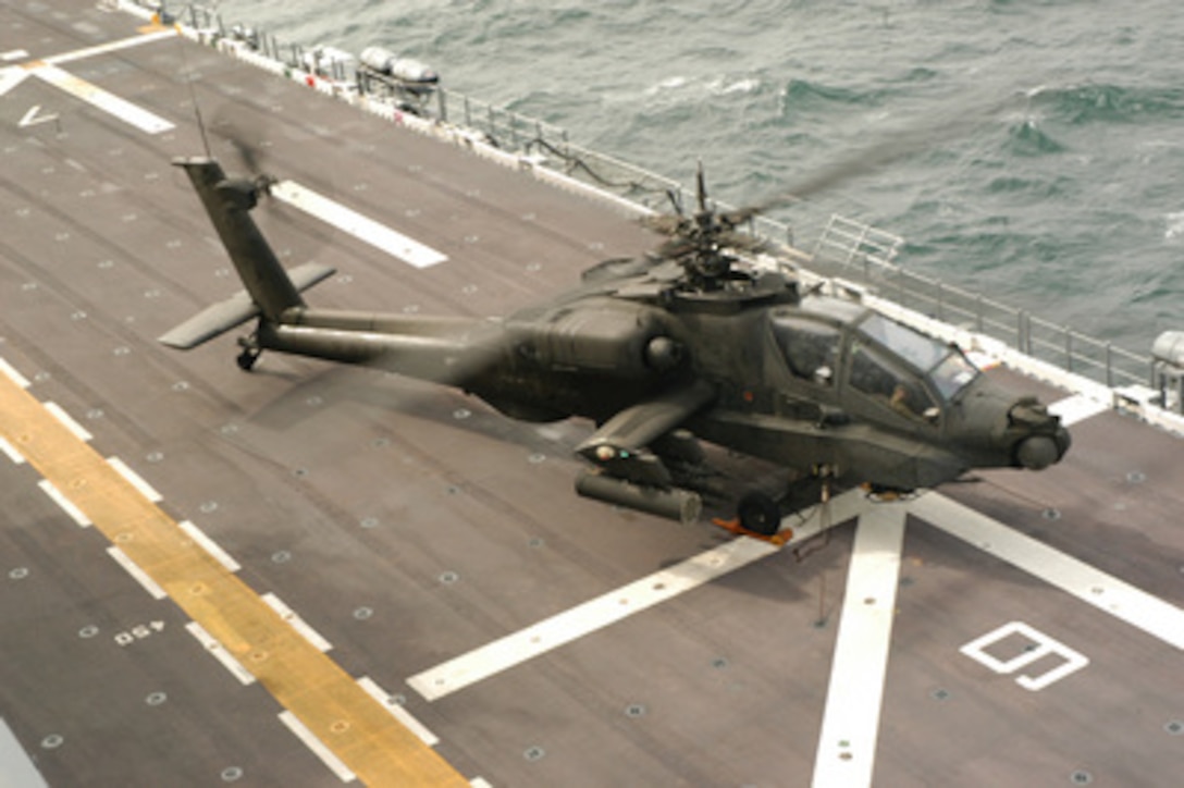 The aircrew of a U.S. Army AH-64 Apache helicopter conducts preflight checks before lifting off from the USS Nassau (LHA 4) during joint shipboard weapons and ordnance training as the ship operates in the Atlantic Ocean on Feb. 1, 2005. Army personnel are aboard the amphibious assault ship to train alongside Navy aviation ordnancemen in a joint training environment. 