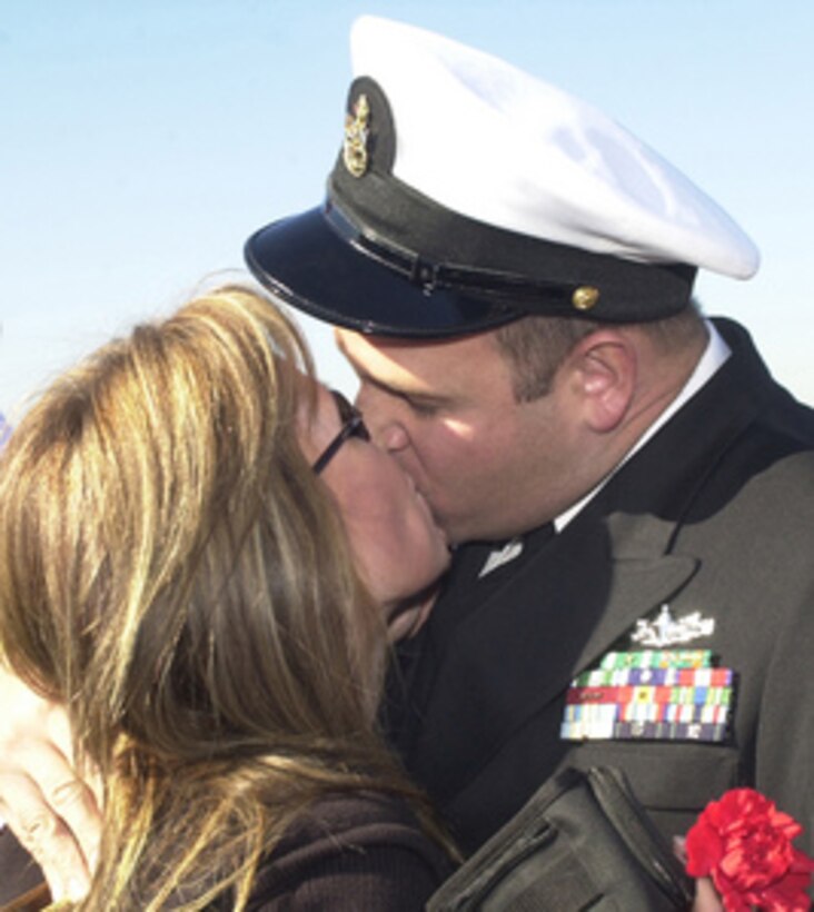 Chief Petty Officer Dominic Brunozzi kisses his wife Diane upon his return to Naval Station San Diego, Calif., on Feb. 2, 2004, after a six-month deployment aboard the USS Curts (FFG 38). The guided missile frigate Curts was deployed to the U.S. Naval Forces Southern Command area in support of operations against the illegal smuggling of narcotics. Brunozzi is a Navy engineman. 